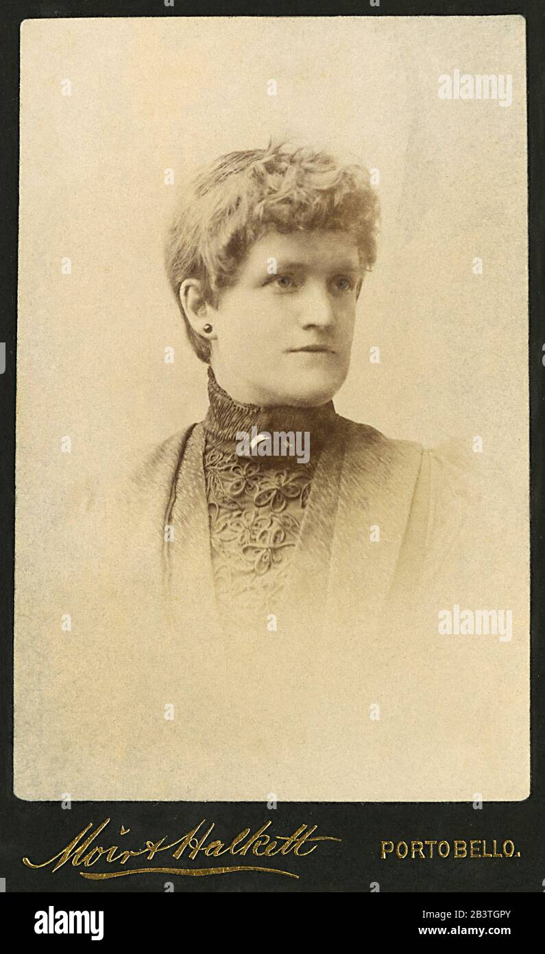 Portrait d'un jeune homme ou d'une jeune femme victorienne ou édouardienne dans un ancien studio de photographie. Banque D'Images