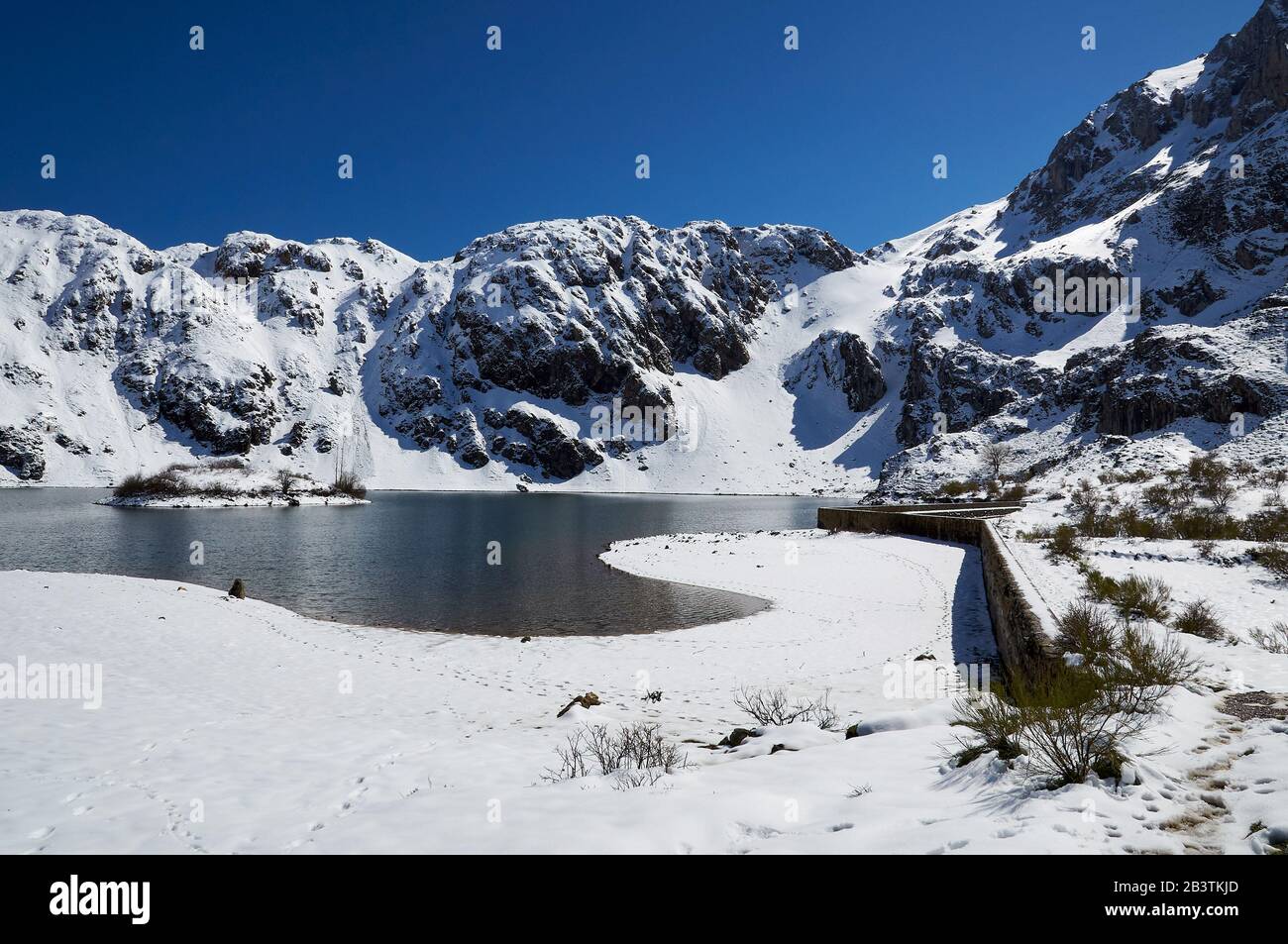 Paysage enneigé d'hiver du lac de montagne du Lago del Valle et pics de montagne escarpés en une journée ensoleillée (Valle del Lago, Soriedo Natural Park, Asturies, Espagne) Banque D'Images
