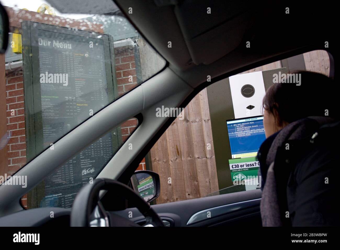 Femme commandant son McDonalds au drive-in, Royaume-Uni Banque D'Images