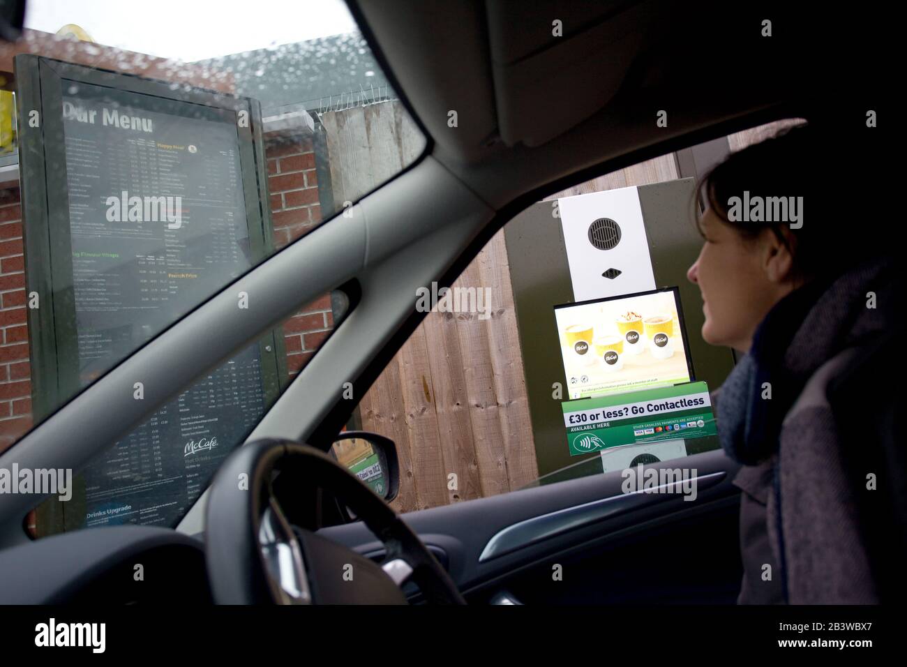 Femme regardant le menu du Service au volant et McDonalds. Angleterre Banque D'Images