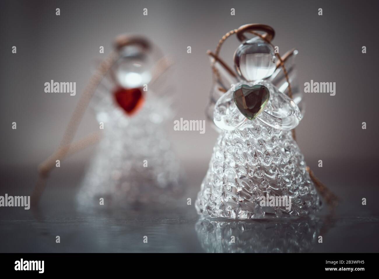 Deux petites statuettes d'ange en verre avec des coeurs dans les mains Banque D'Images