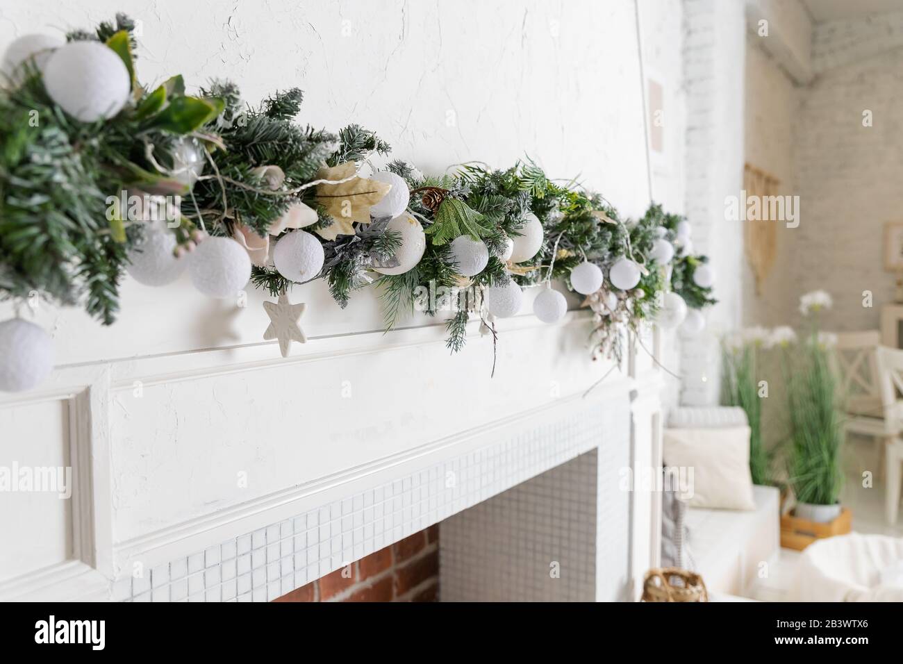 Décoration de Noël avec cheminée dans le salon.guirlande de Noël sur  cheminée blanche. Décor blanc, boules d'or, sapin de Noël, intérieur pour  Photo Stock - Alamy