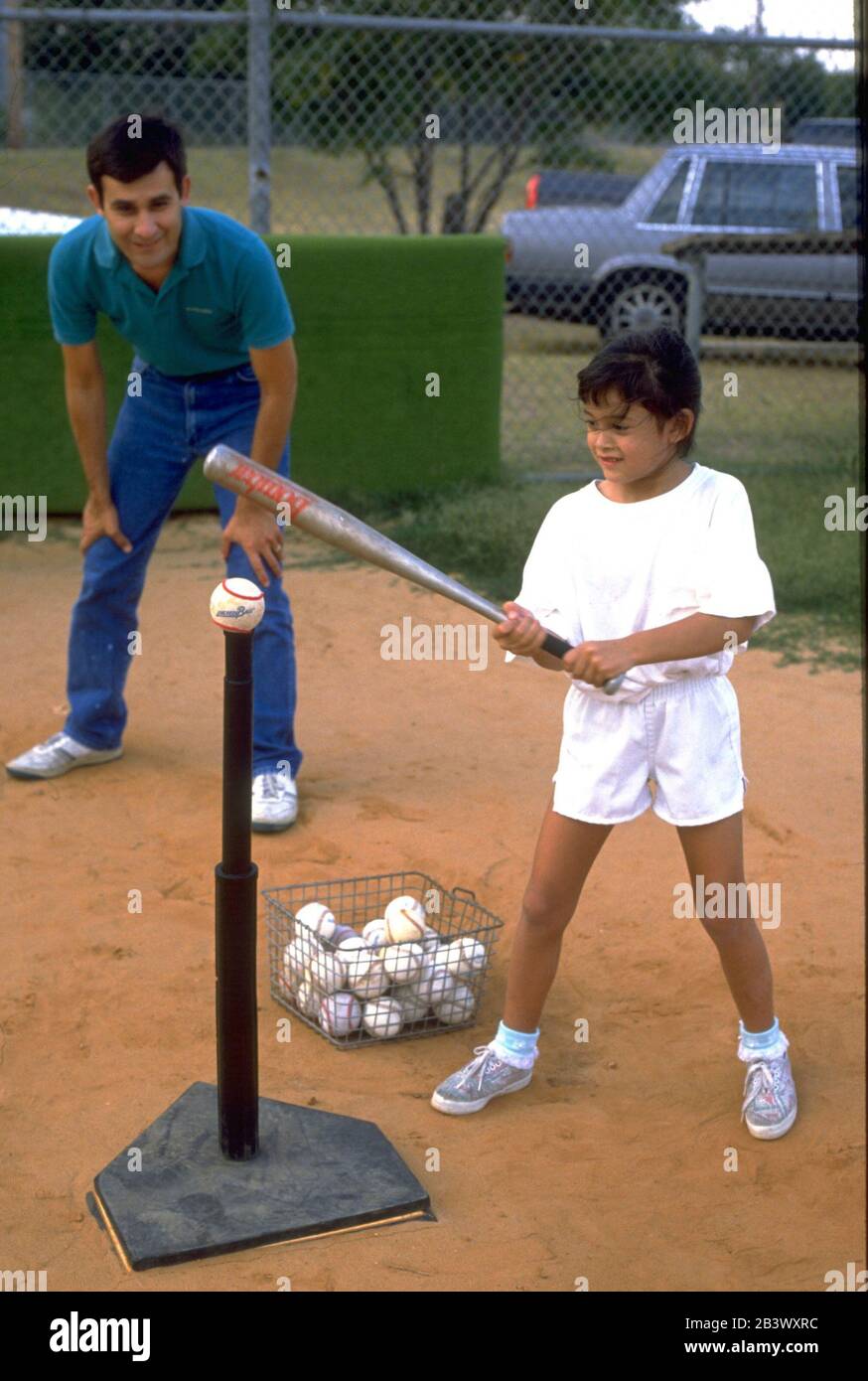 Austin Texas USA: Père hispanique entraîneur de sa fille dans T-ball.©Bob Daemmrich Banque D'Images