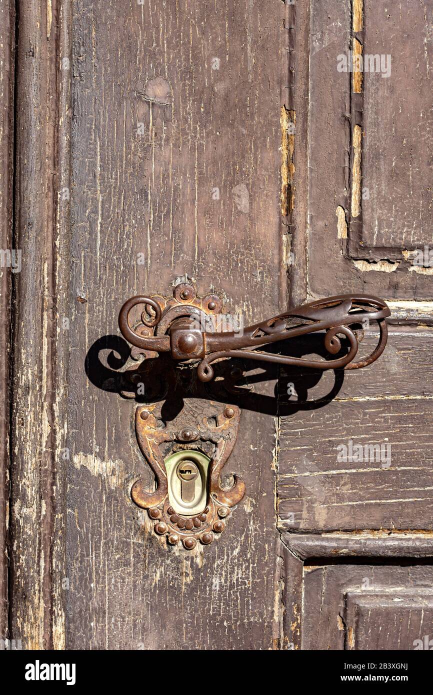 fermez la vieille porte en bois vintage décorée avec un cadre en fer et une poignée de porte . Banque D'Images