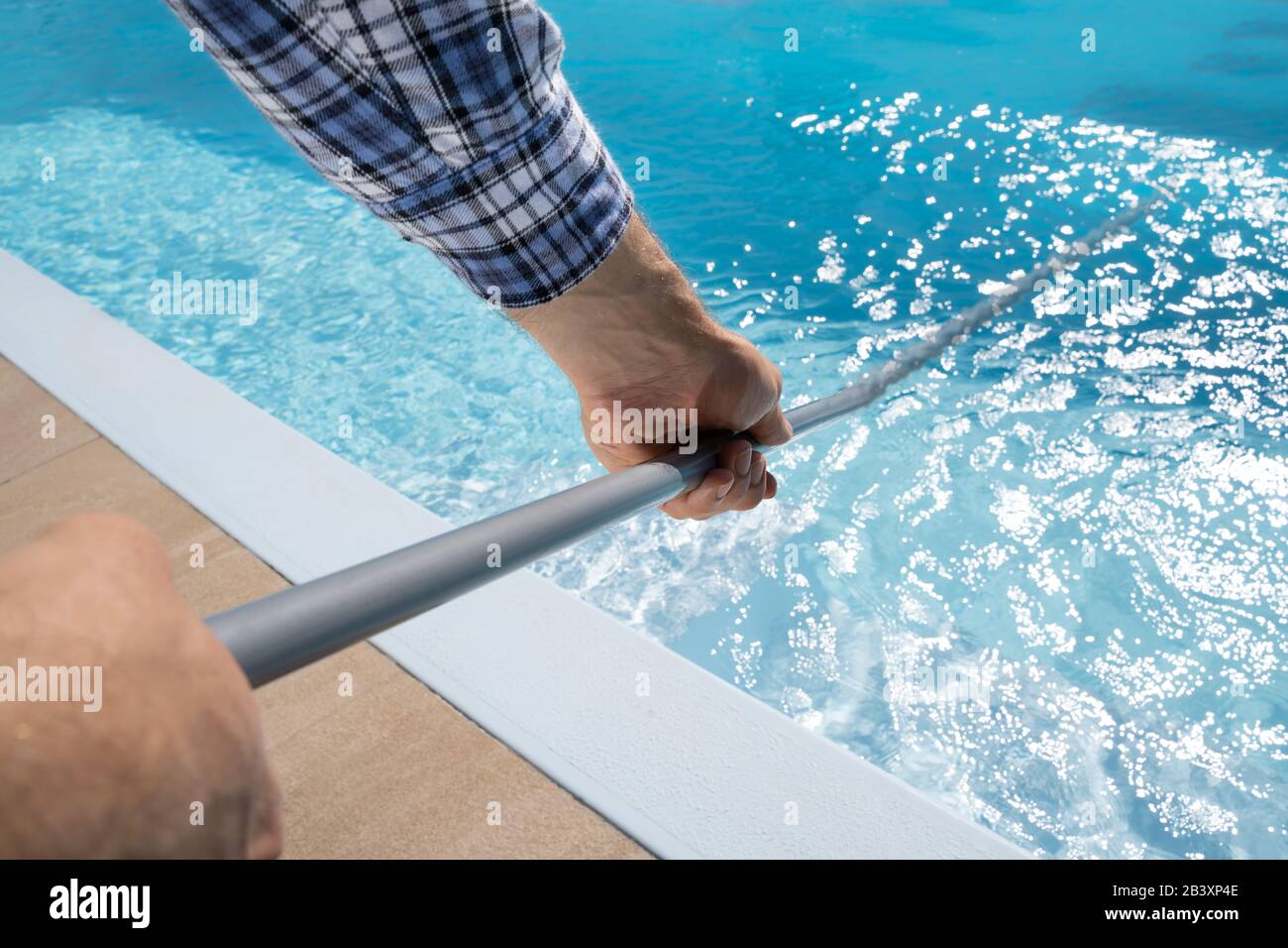 Travailleur Masculin Dans La Piscine De Nettoyage Uniforme Banque D'Images