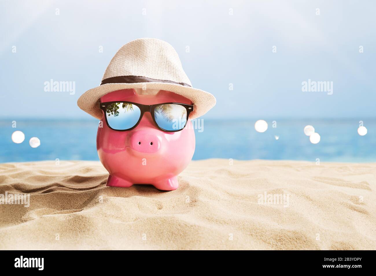 Piggy Bank Rose Avec Lunettes De Soleil Noires Sur La Plage Banque D'Images