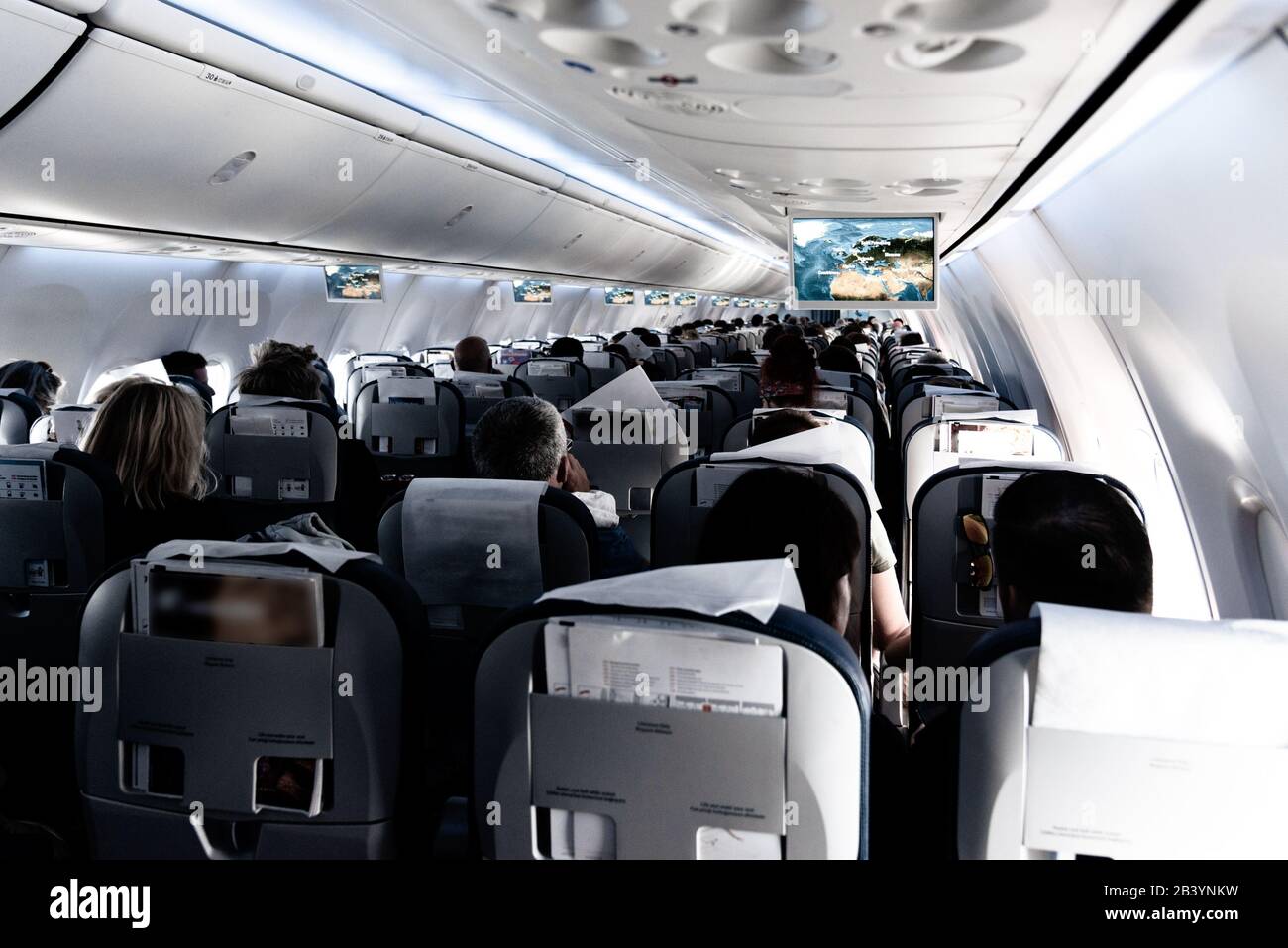 Vue sur la cabine de passagers d'avions commerciaux avec des voyageurs non reconnaissables assis pendant le vol. Concept de voyage. Banque D'Images