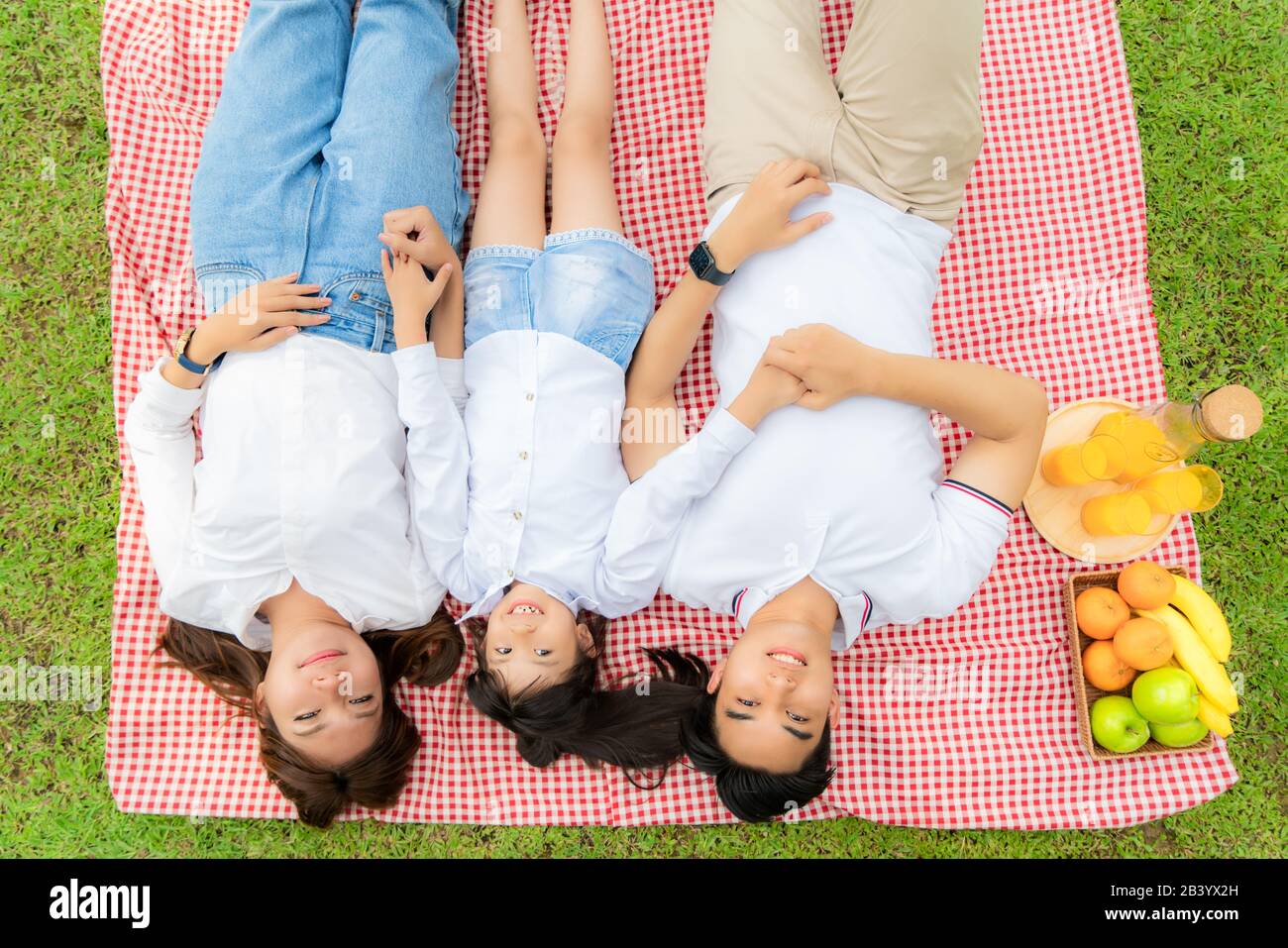 Famille des adolescents asiatiques bonne vacances pique-nique moment dans le parc avec père, mère et fille allongé sur tapis et sourire à heureux passer des vacances togerte Banque D'Images