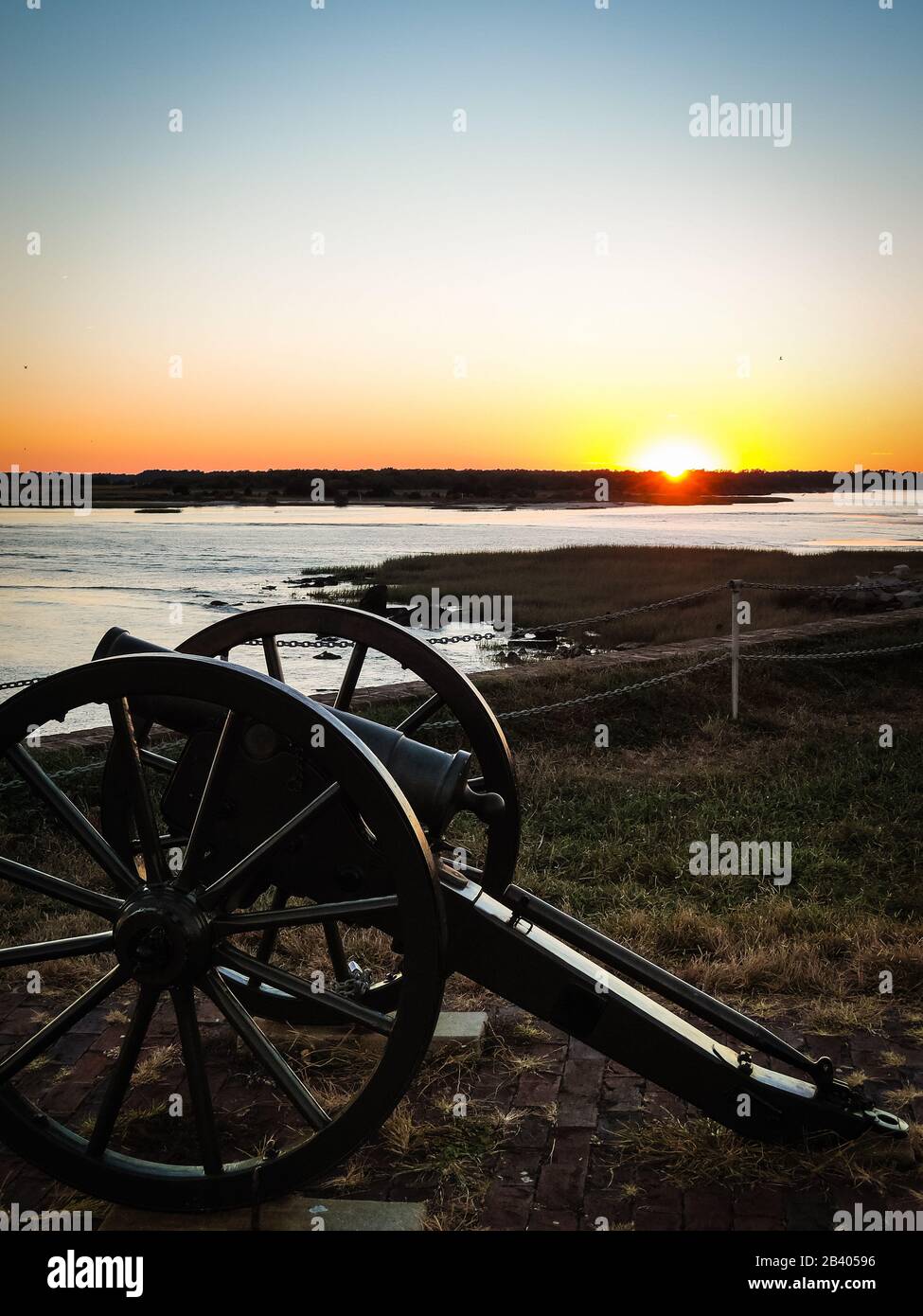 Canon historique de guerre civile sur l'île de fort Sumter près de Charleston, Caroline du Sud avant beau coucher de soleil orange. Aucune personne visible, copyspace. Banque D'Images