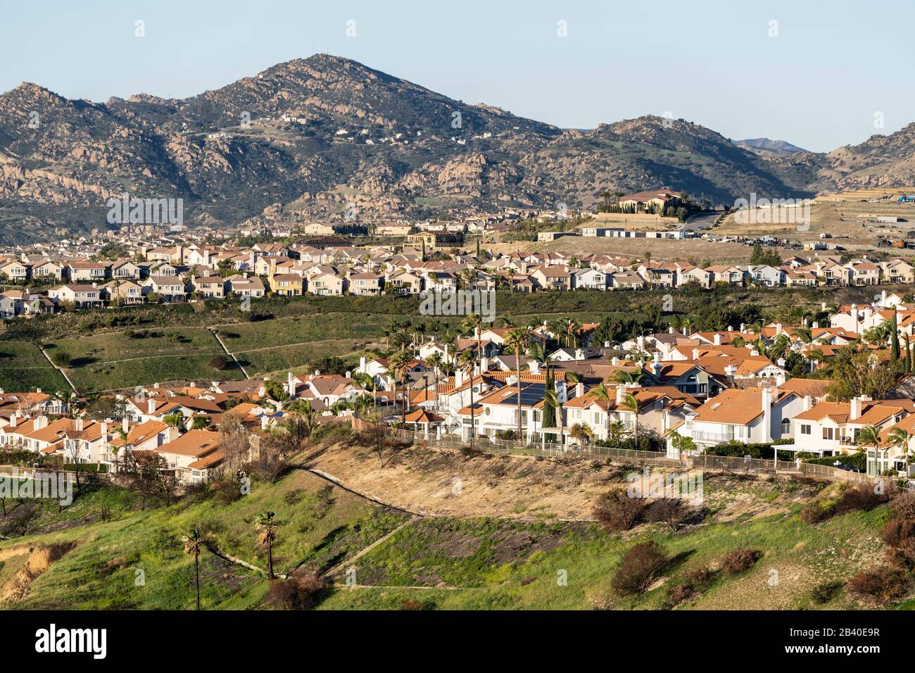 Rangées de maisons en haut d'une colline dans le nord de Los Angeles, Californie. La construction en cours et les montagnes de Santa Susana sont en arrière-plan. Banque D'Images