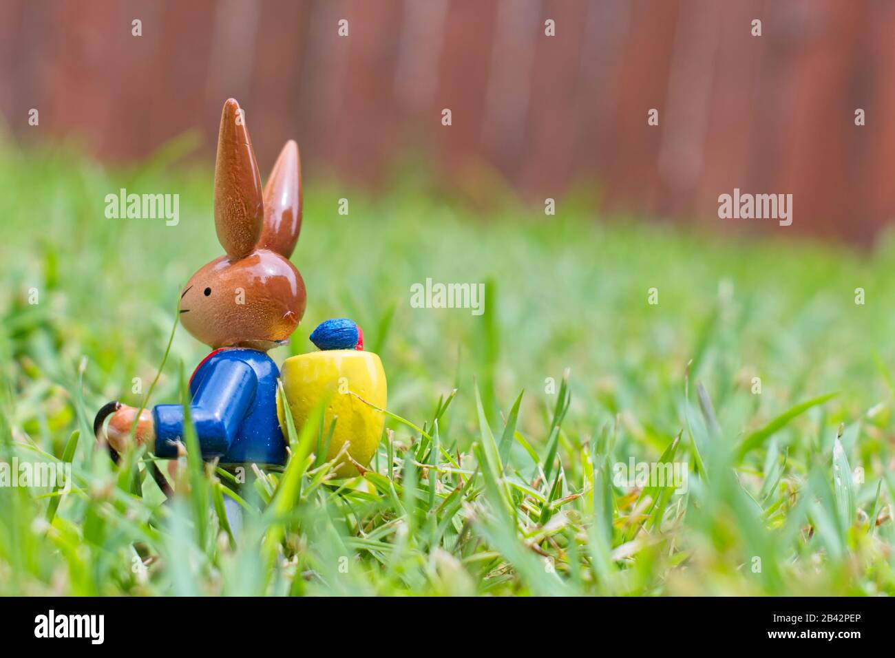 Jouet en bois lapin de Pâques avec œufs dans l'herbe Banque D'Images