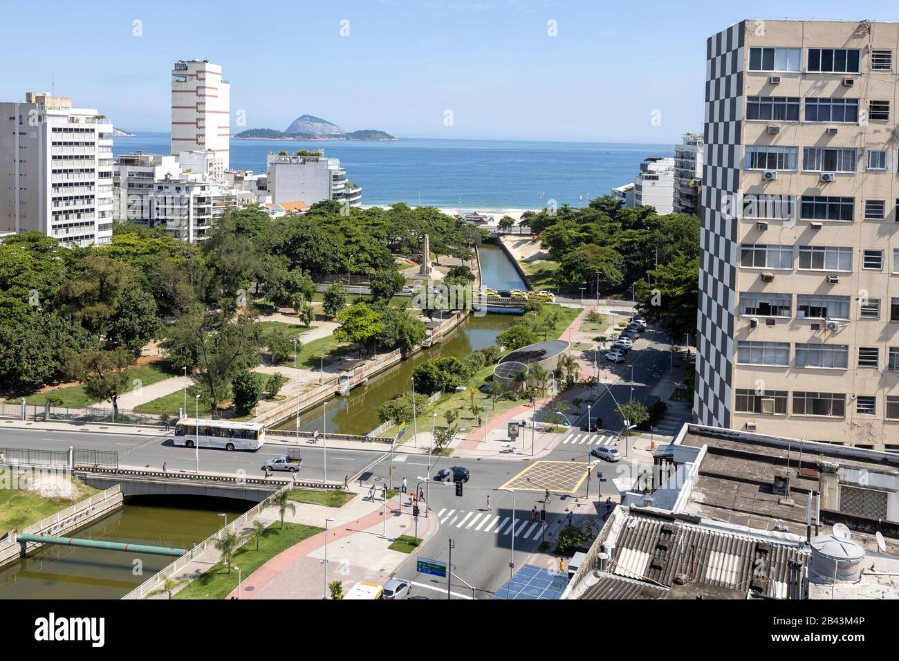 Intersection dans le quartier de Leblon à Rio de Janeiro, au Brésil, avec des bâtiments de grande hauteur et parc avec système de drainage en premier plan Banque D'Images