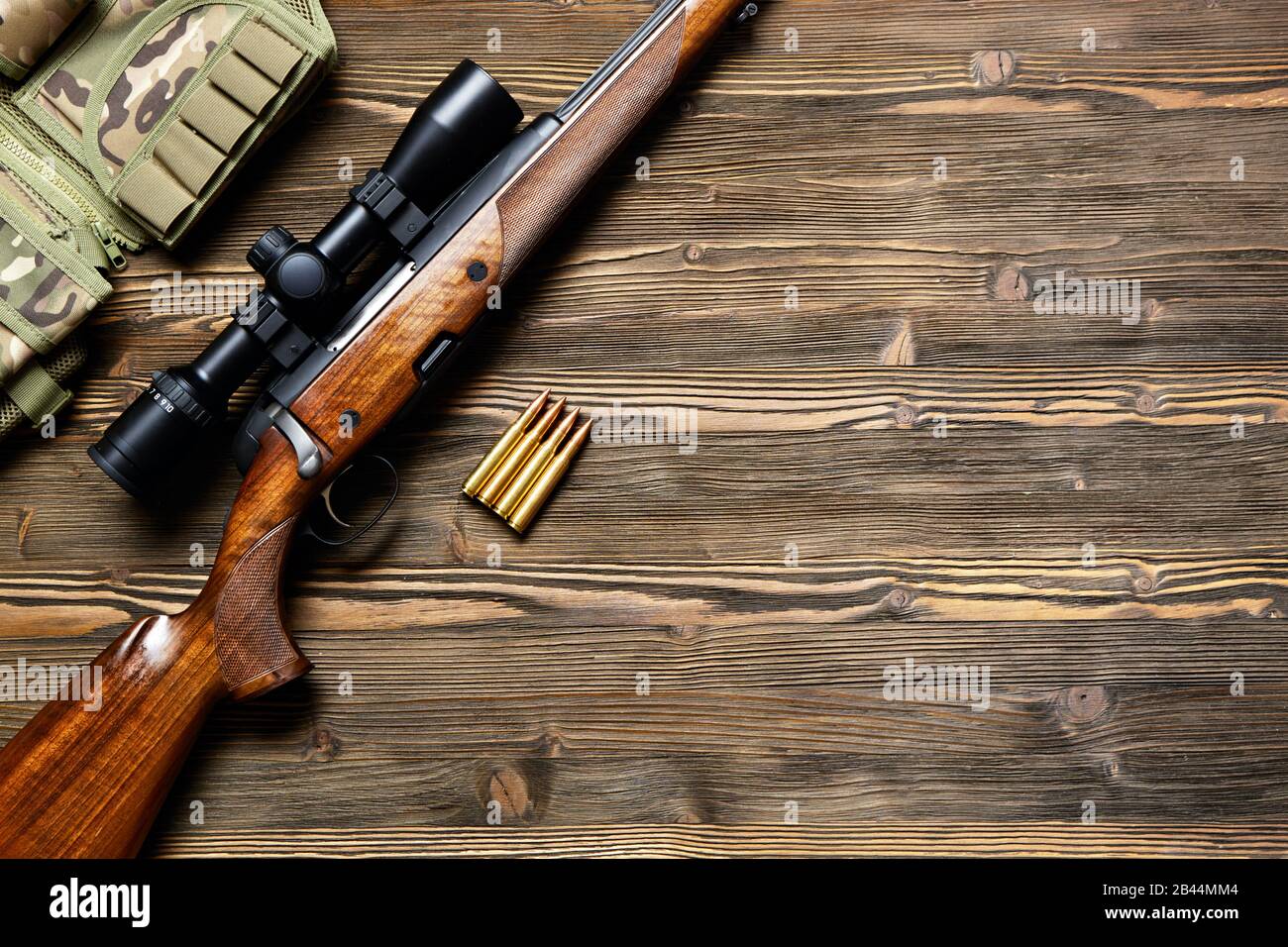 Fusil de chasse et munitions sur fond en bois sombre.vue sur le dessus. Banque D'Images