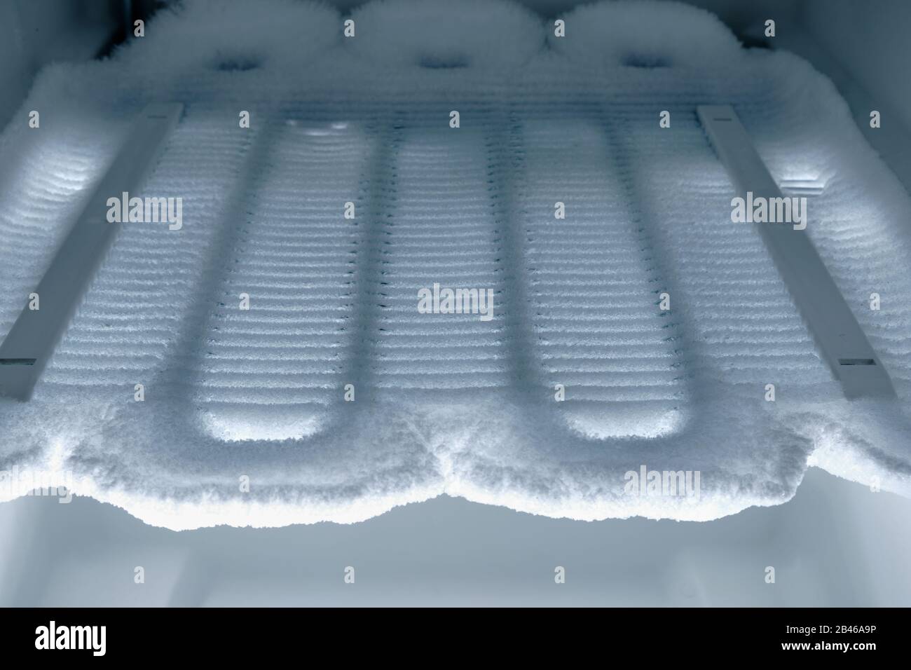 Temps de dégivrage : vue dans le congélateur sur les serpentins de refroidissement complètement couverts de glace. Banque D'Images