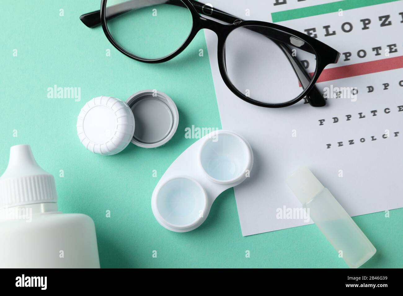 Lunettes, étui pour lentilles de contact et tableau de test des yeux sur  fond de menthe, vue du dessus Photo Stock - Alamy