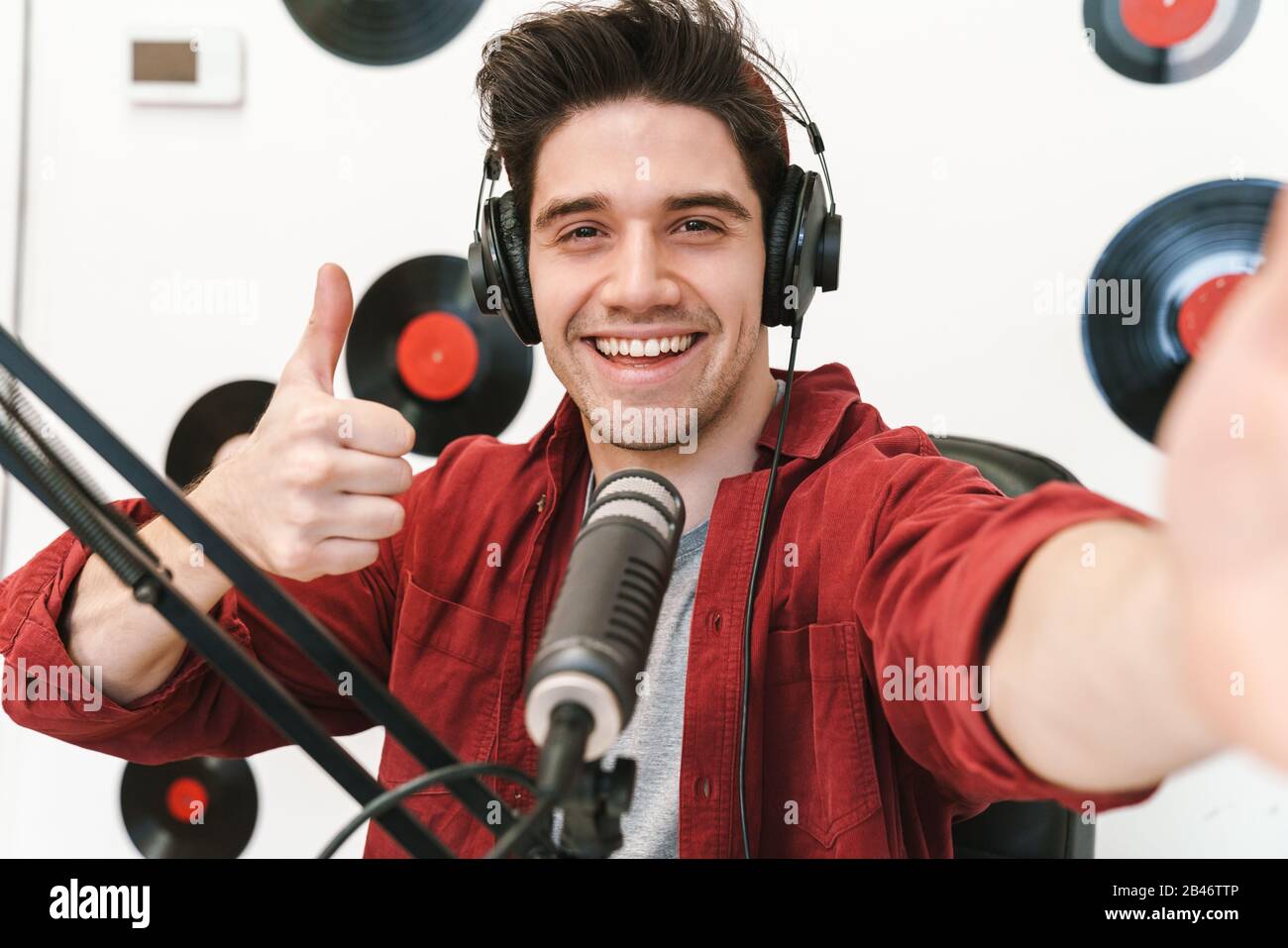 Image d'un jeune homme caucasien heureux qui se présente dans un programme radio tout en réalisant un enregistrement de podcast pour un spectacle en ligne Banque D'Images