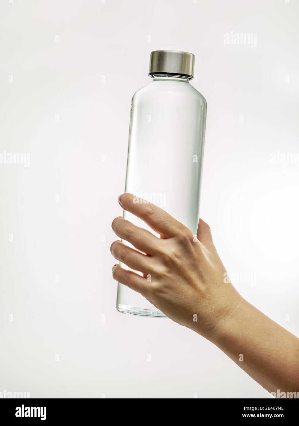 Flacon en verre réutilisable à main avec eau potable isolée sur fond blanc Banque D'Images
