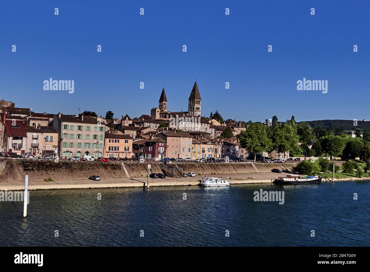 France , vue sur la ville de Tournus le long de la rivière Saone, département de Bourgogne-Franche-Comté, , ancien castrum romain, nous pouvons voir les célèbres clochers de la célèbre église catholique de Saint-Philibert (dans le style roman bourguignonne). Il y a un bateau sur la Saône. Banque D'Images