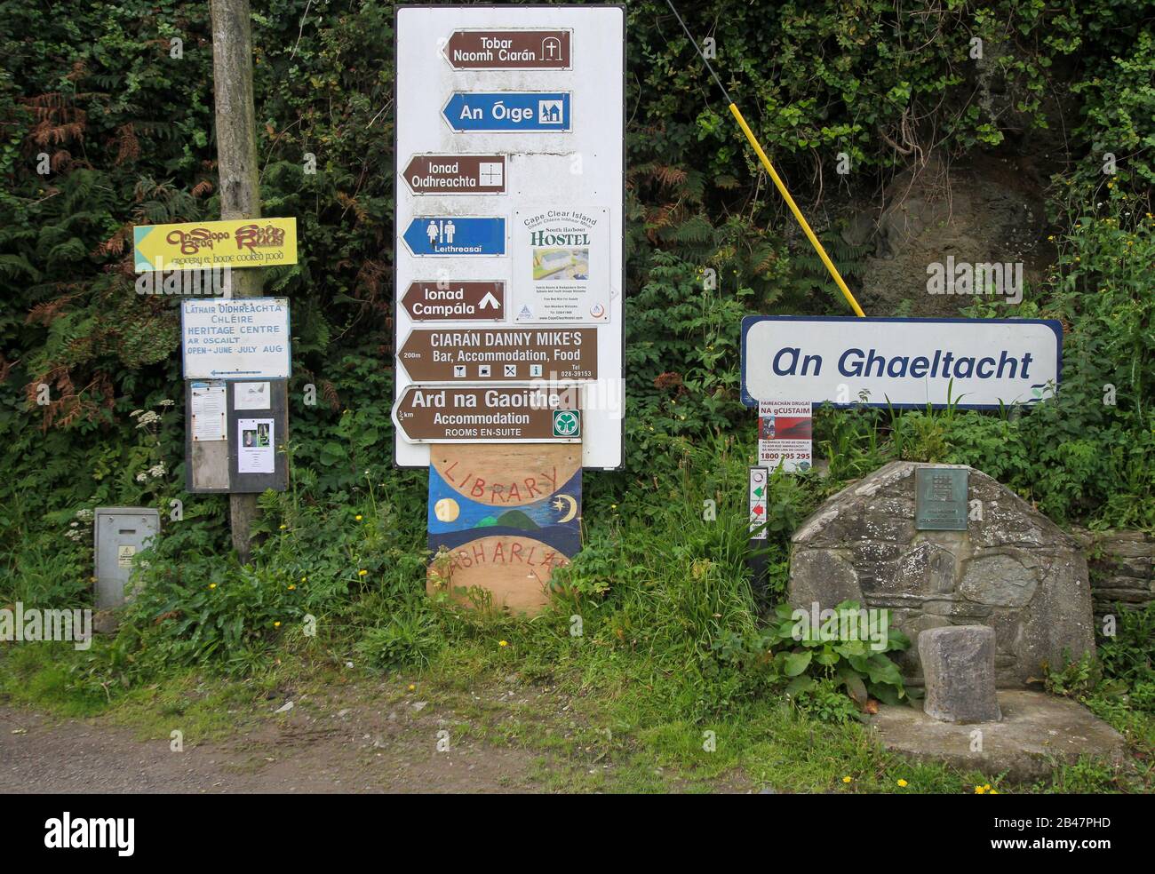 Des panneaux indiquant la direction locale au port de Cape Clear Island sont à la disposition des visiteurs arrivant sur l'île de Gaelic Speaking (Gaeltacht) dans le comté de Cork, en Irlande. Banque D'Images