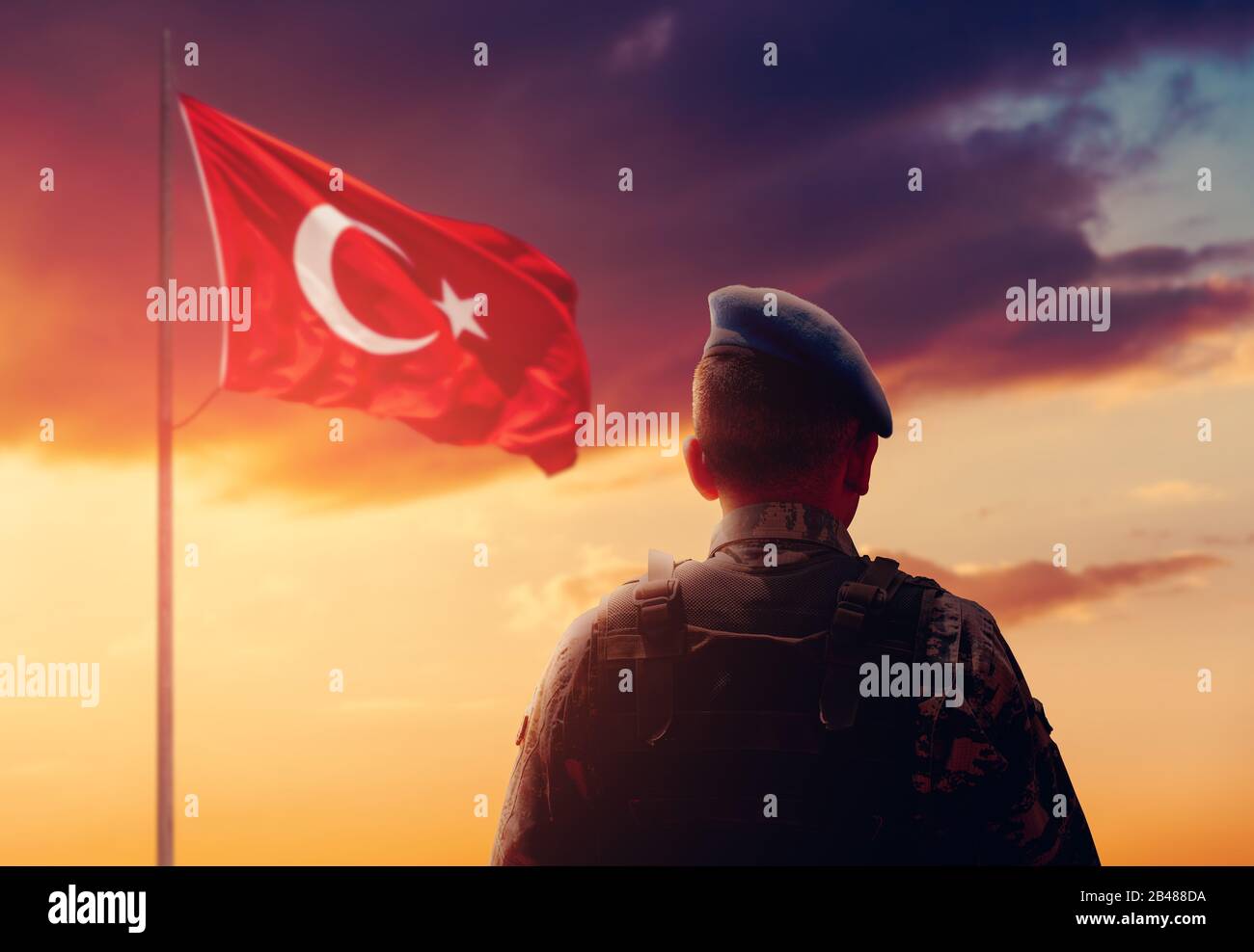 Le soldat turc est debout et salue le drapeau turc sur son devoir de montre Banque D'Images