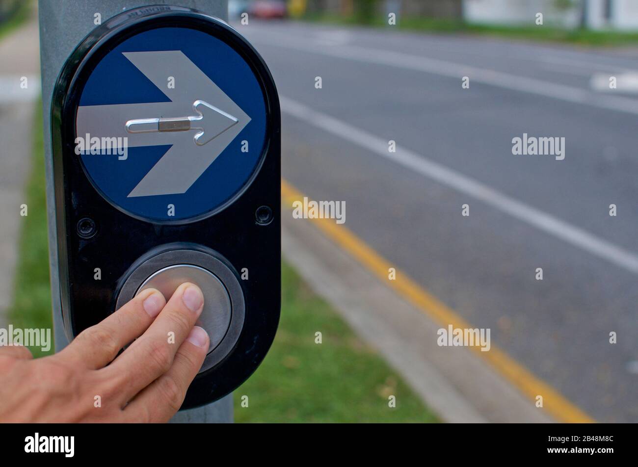 Appuyez avec les doigts sur un bouton du feu de signalisation à Brisbane. Cela peut être utilisé comme concepts pour prendre des décisions et aller de l'avant Banque D'Images