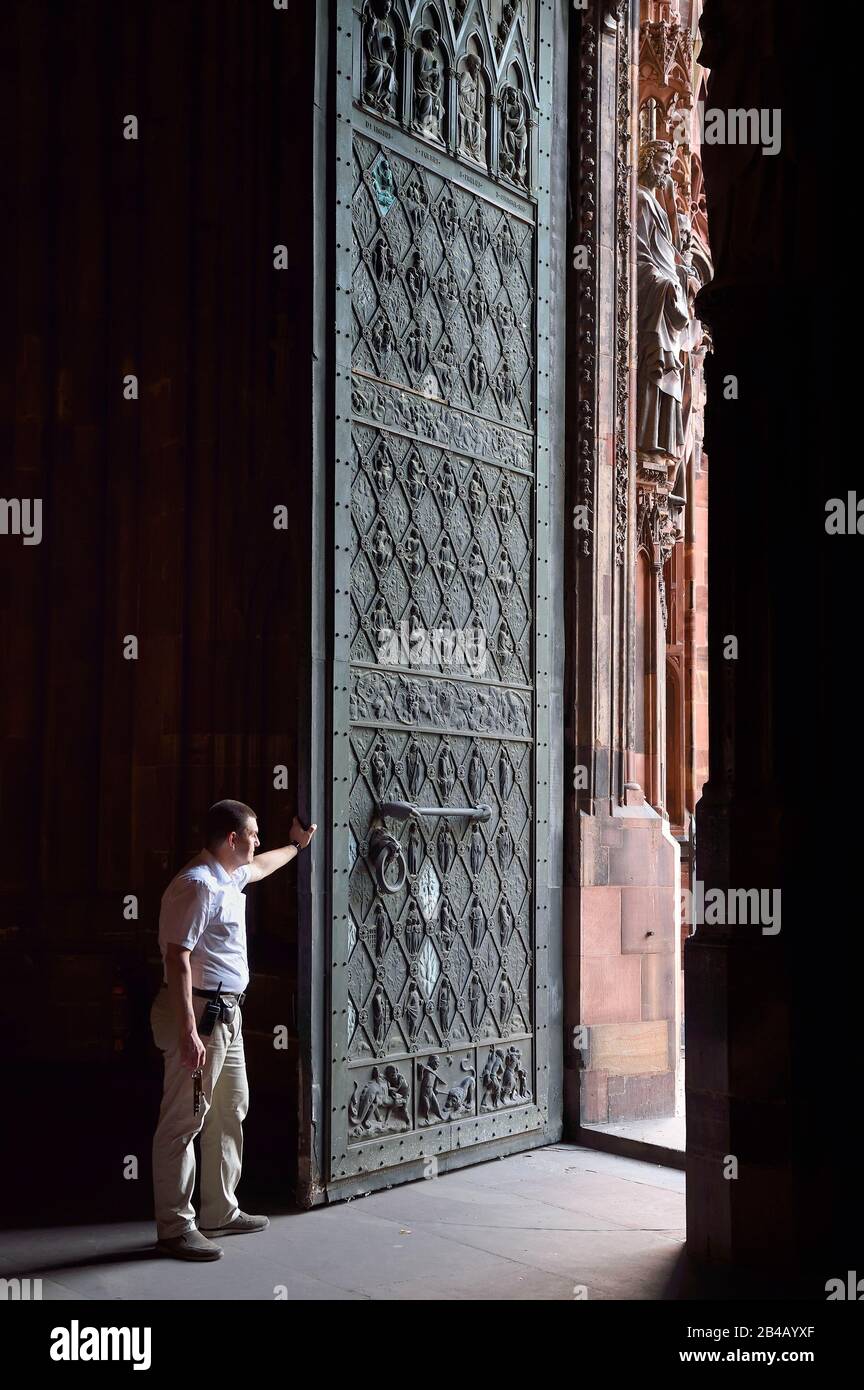 France, Bas-Rhin, Strasbourg, vieille ville classée au patrimoine mondial par l'UNESCO, cathédrale notre-Dame, Sacristan Michel Bolli ouvre la porte principale de la façade occidentale en début de matinée Banque D'Images