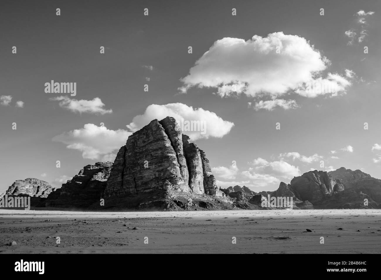 Royaume de Jordanie, désert de Wadi Rum, paysage ensoleillé de jour d'hiver paysage avec des nuages blancs et des couleurs chaudes. Belle photographie de voyage. Un magnifique désert peut être exploré lors d'un safari. Noir et blanc Banque D'Images