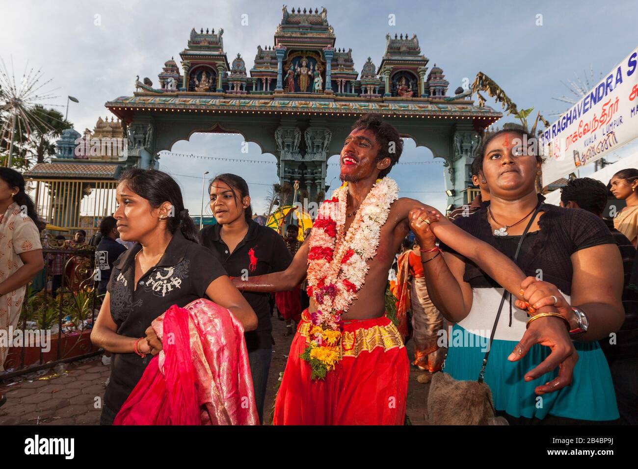 Malaisie, État de Selangor, grottes de Batu, festival hindou procession de Thaipusam, jeune homme dans une transe recevant le soutien de ses sœurs Banque D'Images