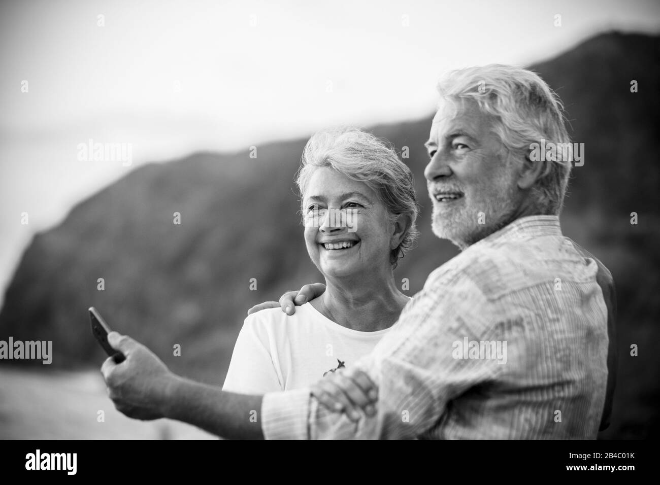 Beau portrait romantique de couple senior heureux sourire et hug eachautre avec amour - toujours ensemble concept et actif vieux vie heureuse - blanc clair fond et les personnes souriant Banque D'Images