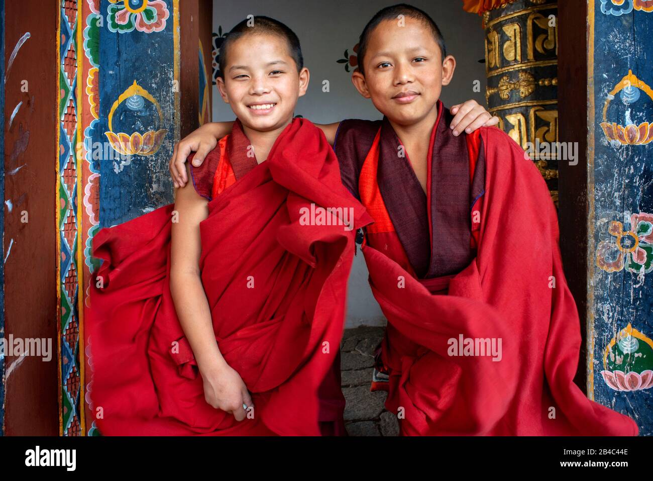 Deux jeunes moines à l'entrée du temple de Chimi Lhakhang dans le village de Lobesa Punakha Bhoutan Banque D'Images