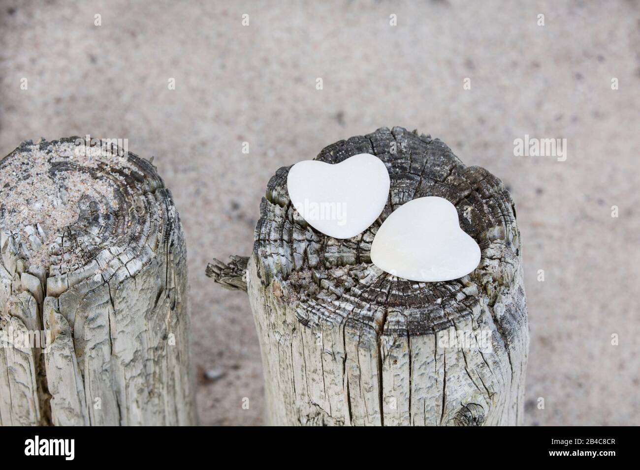 deux coeurs de pierre blanche sur des poteaux en bois à l'ouest sur une plage de sable Banque D'Images
