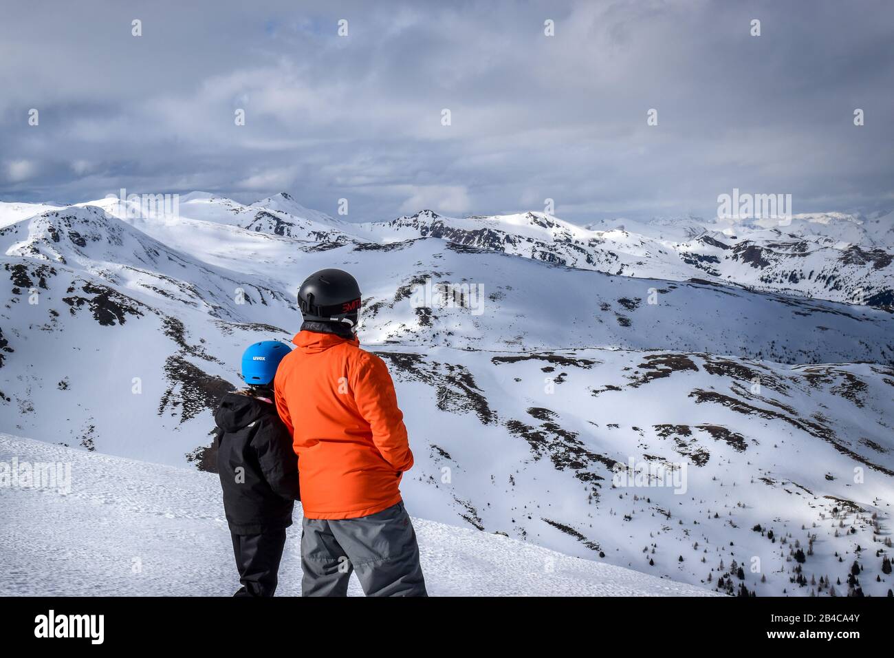 Deux personnes, un père et une fille debout sur les Alpes autrichiennes en regardant la distance de neige Banque D'Images