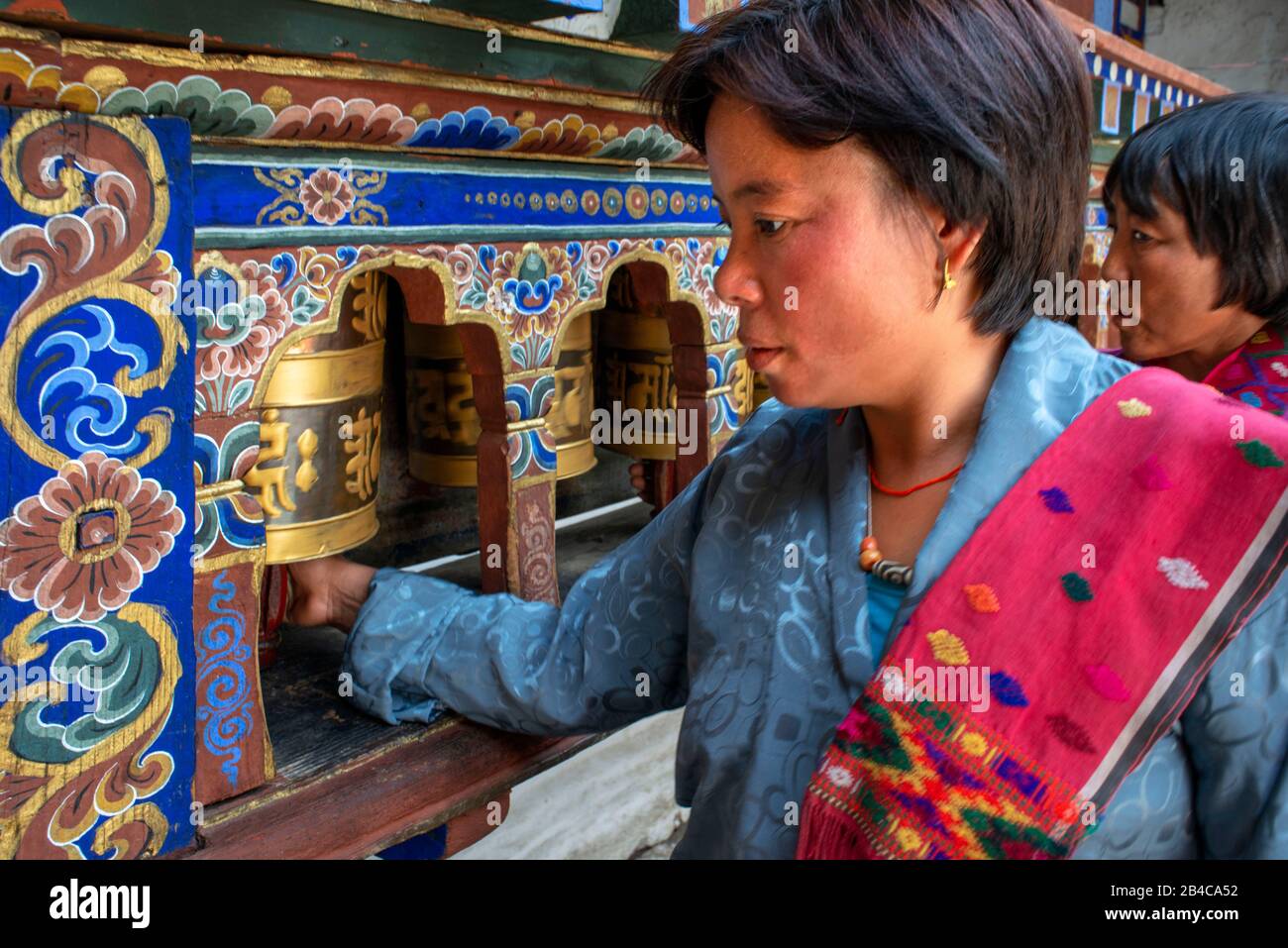 Roue de prière en rotation au temple de Kyichu Lhakhang près de Paro dans les montagnes de l'Himalaya Bhoutan, Asie du Sud, Asie. Cour intérieure avec brûleur à encens et Banque D'Images