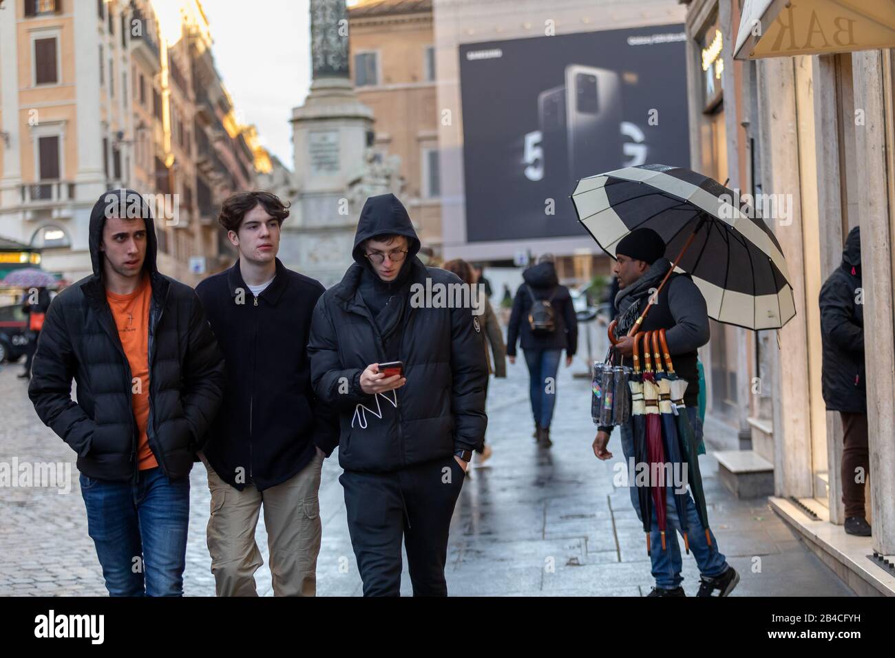 Rome, Italie - 4 mars 2020 : fournisseur de parapluie dans le centre historique. Un immigrant vend ses parapluies aux citoyens et aux touristes qui str Banque D'Images