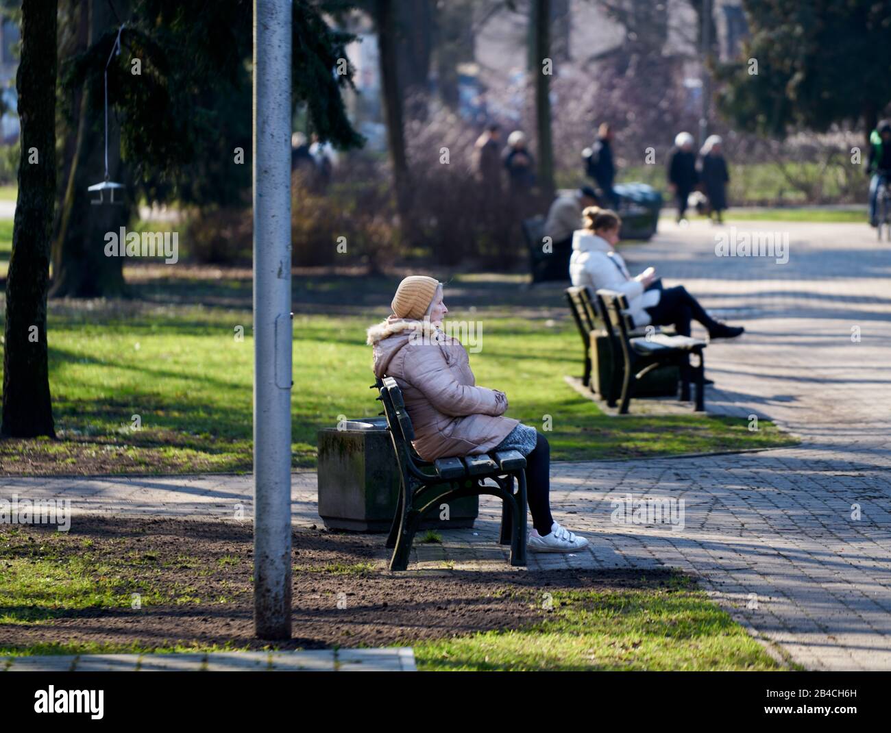 06-03-2020 Riga, Lettonie une femme âgée caucasienne assise sur un banc de parc au soleil. Banque D'Images