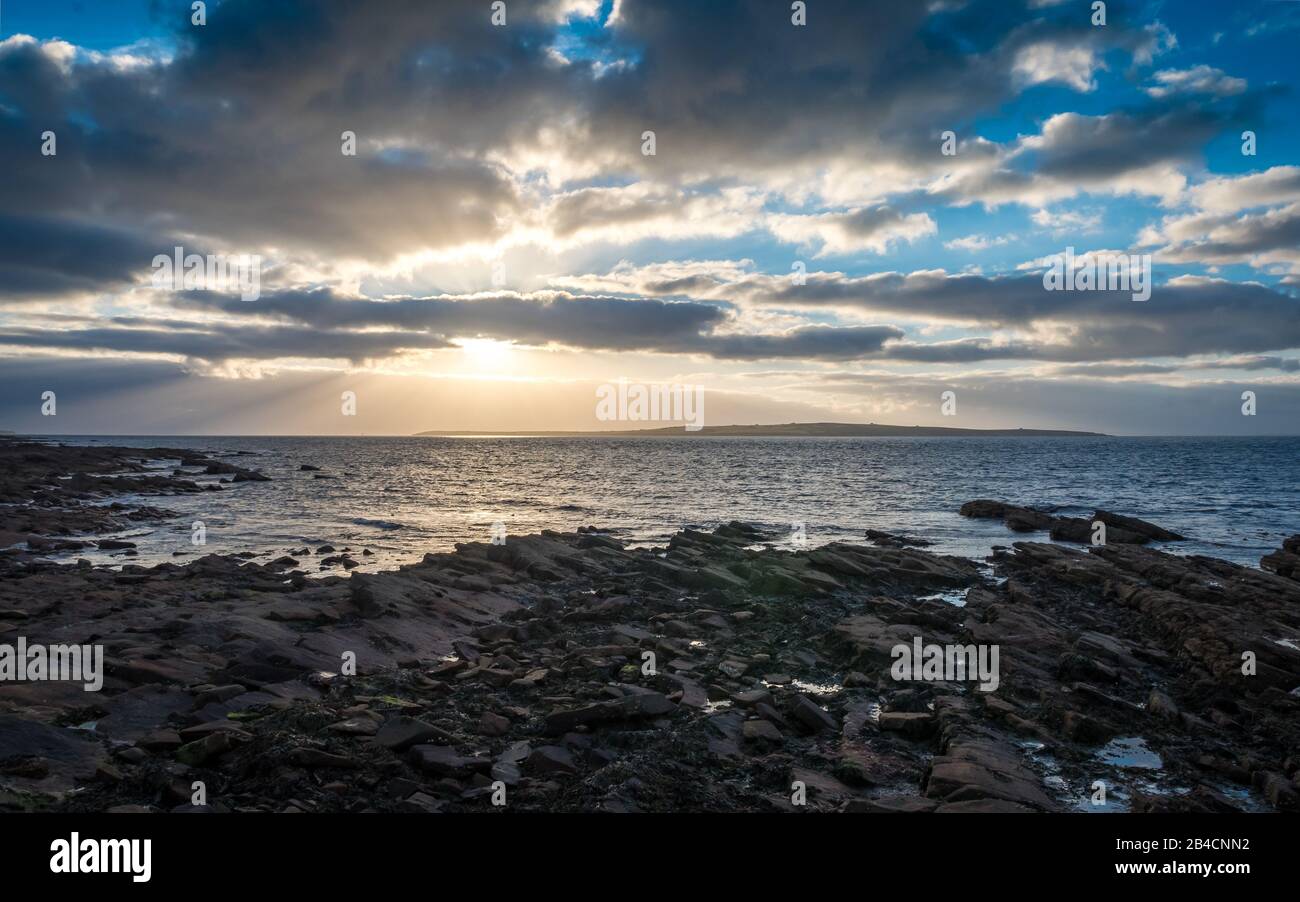Crépuscule coucher de soleil, l'Ecosse du Nord et Le Stroma. Le littoral accidenté de John O'Groats lors d'une soirée dousoyeuse avec l'île De Stroma au loin. Banque D'Images