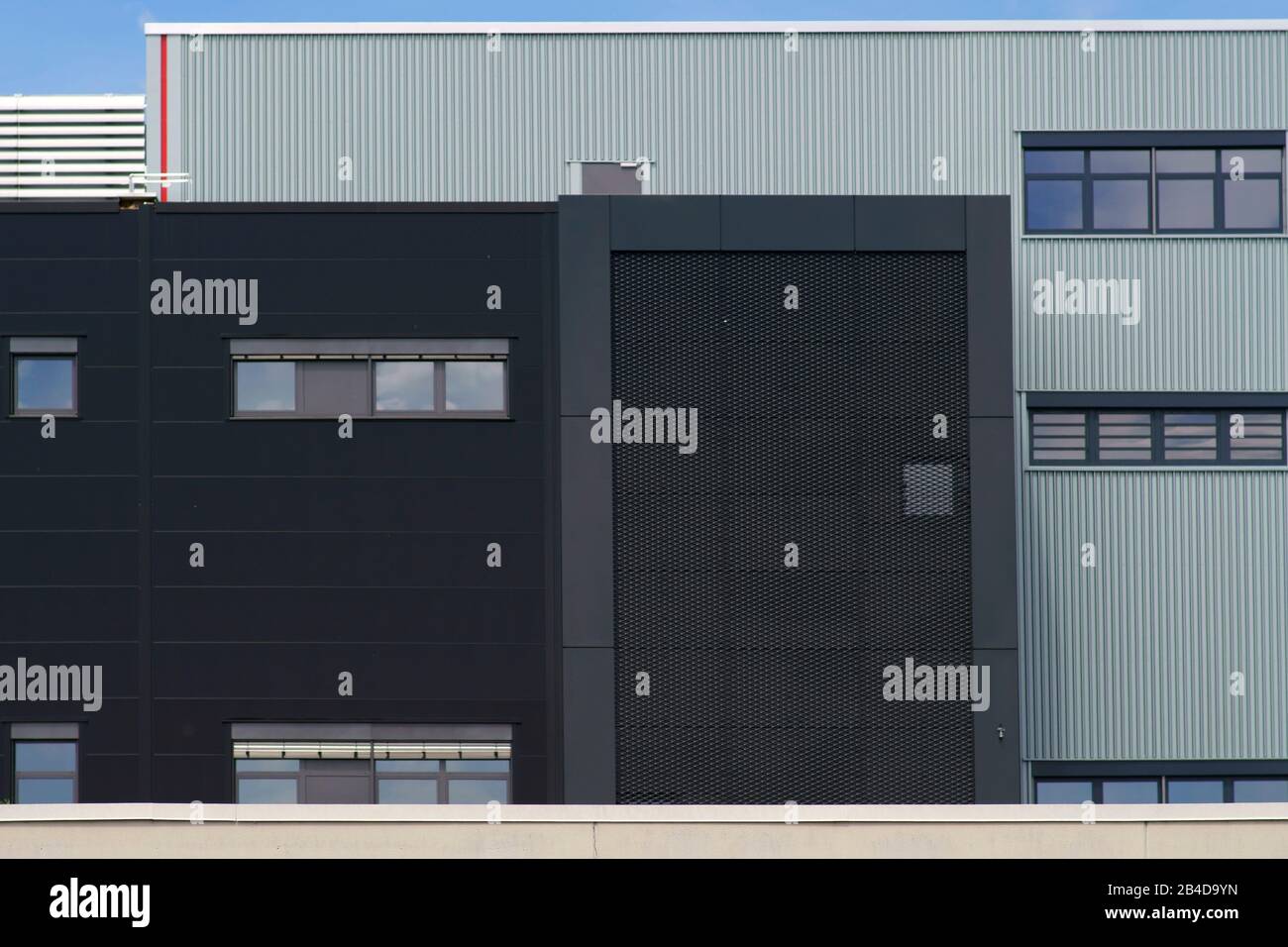 Un bâtiment industriel moderne avec différentes façades métalliques et les grilles. Banque D'Images