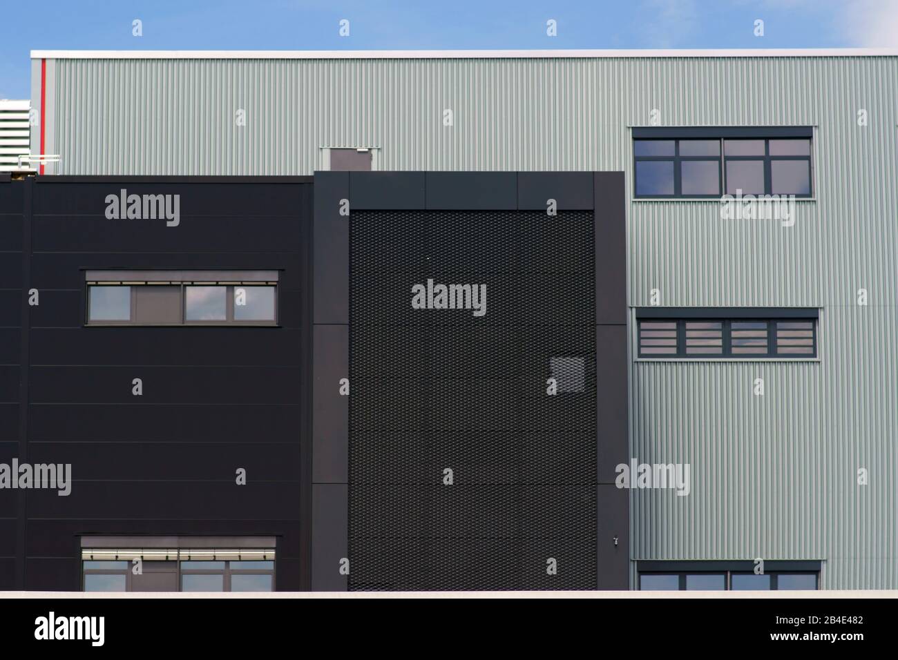 Un bâtiment industriel moderne avec différentes façades métalliques et les grilles. Banque D'Images
