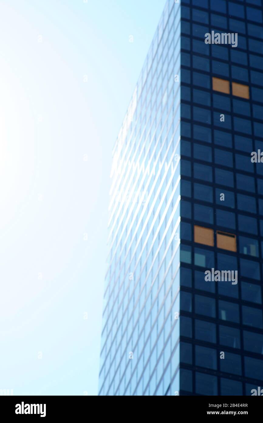 L'angle et le bord latéral d'un gratte-ciel moderne dans la lumière arrière. Banque D'Images