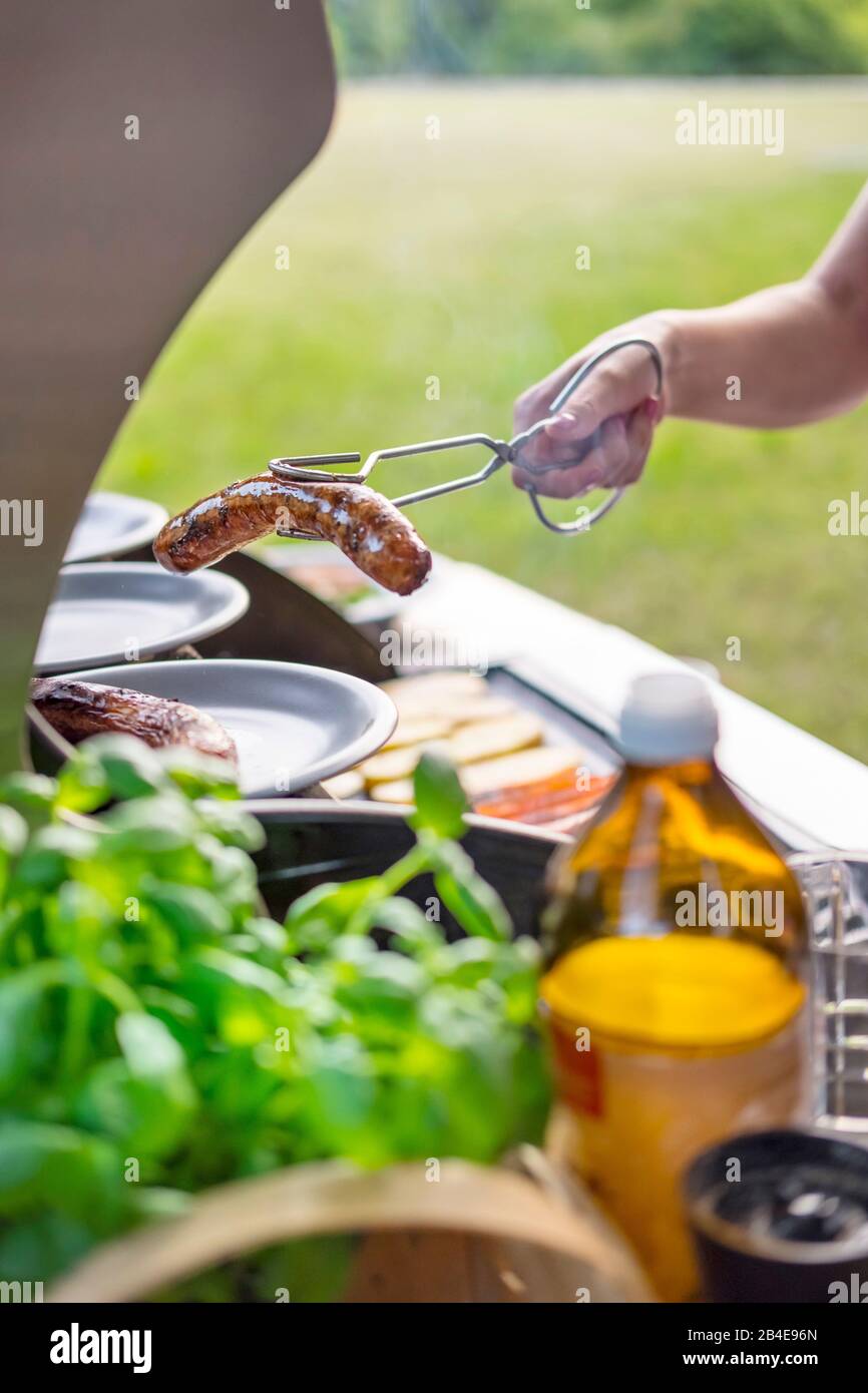 Pinces pour barbecue à main avec saucisses pour grillades, barbecue Banque D'Images