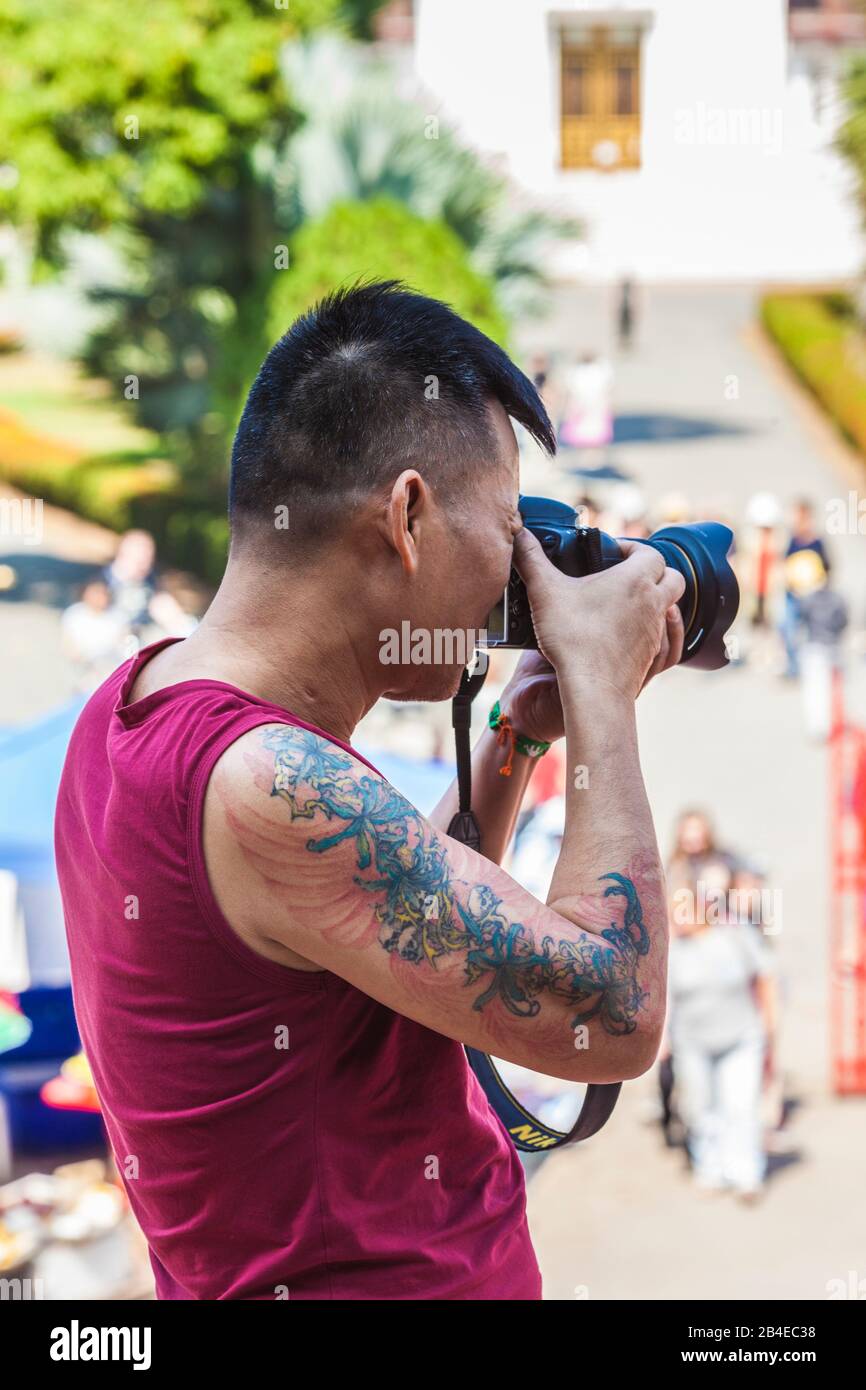 Laos, Luang Prabang, Palais Royal, homme tatoué photographiant, pas de rejets Banque D'Images