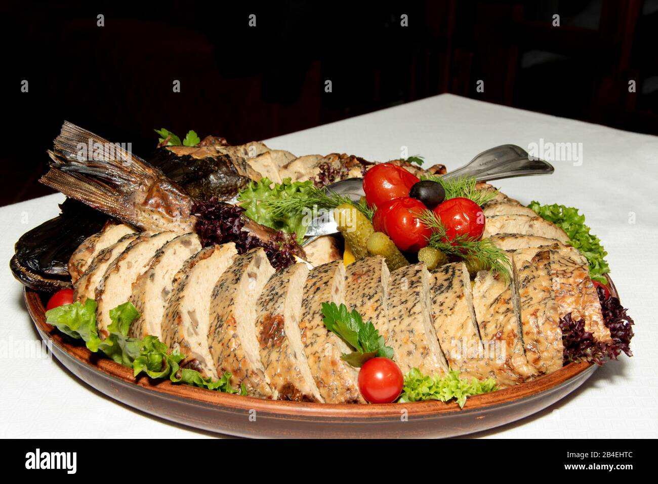 brochet farci cuit au four. servi avec des légumes sur une plaque blanche sur des serviettes rouges sur une place. Gros plan. Série de photos Banque D'Images