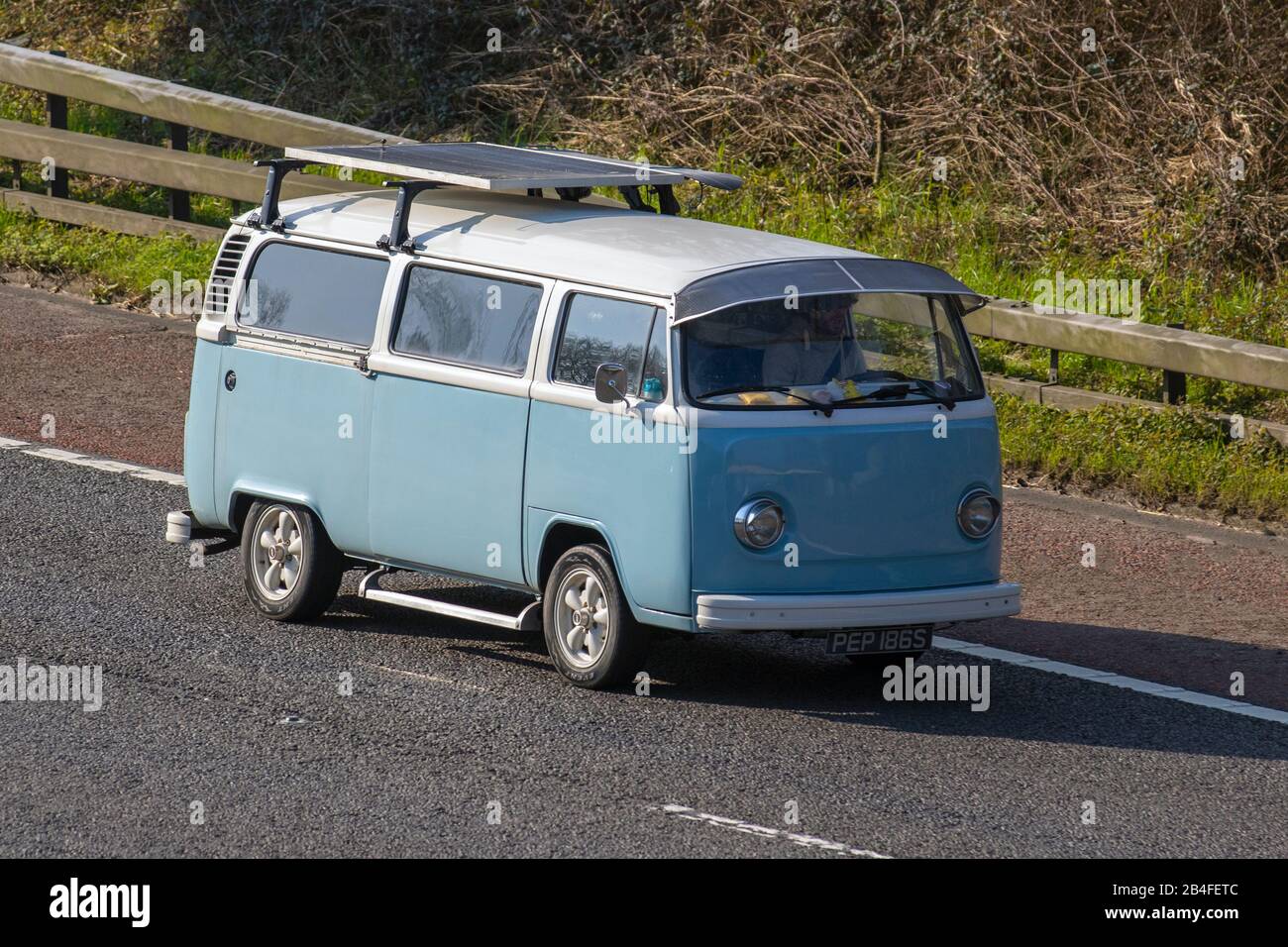 1977 70s blanc bleu VW Volkswagen Bay fenêtre dormobile autohome autodormant conversion, motorhome avec panneau solaire sur la M61 à Chorley, Royaume-Uni Banque D'Images