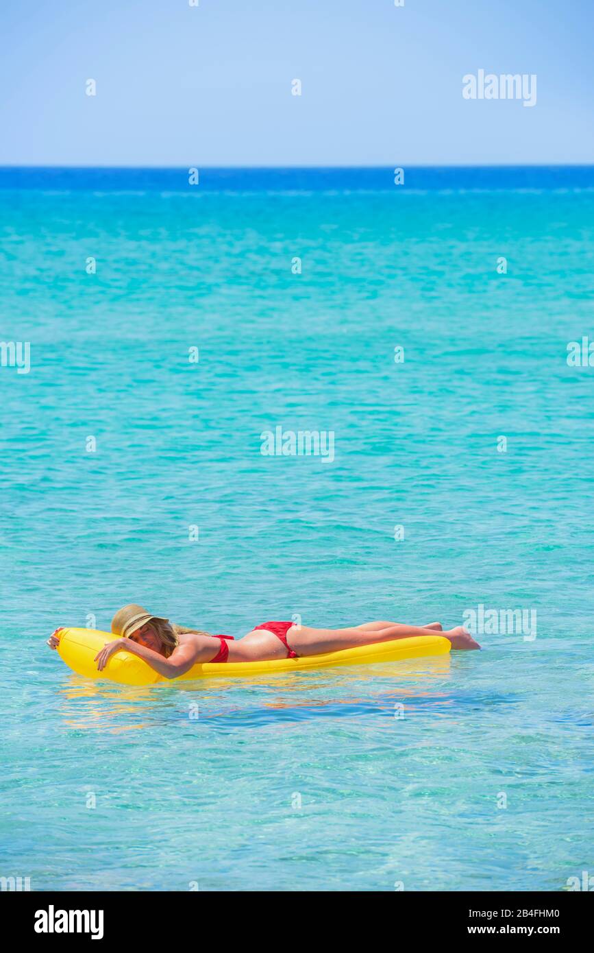 Femme reposant sur matelas gonflable, Formentera, Iles Baléares, Espagne Banque D'Images