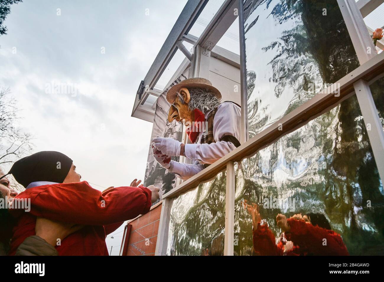 Europe, Suisse, Bâle, manifestation traditionnelle, Bâle Fasnacht, la plus grande de Suisse, patrimoine culturel immatériel de l'humanité, Cortège à la Wettsteinplatz, spectateurs, enfant mendiant à la voiture à thème, homme avec masque Banque D'Images