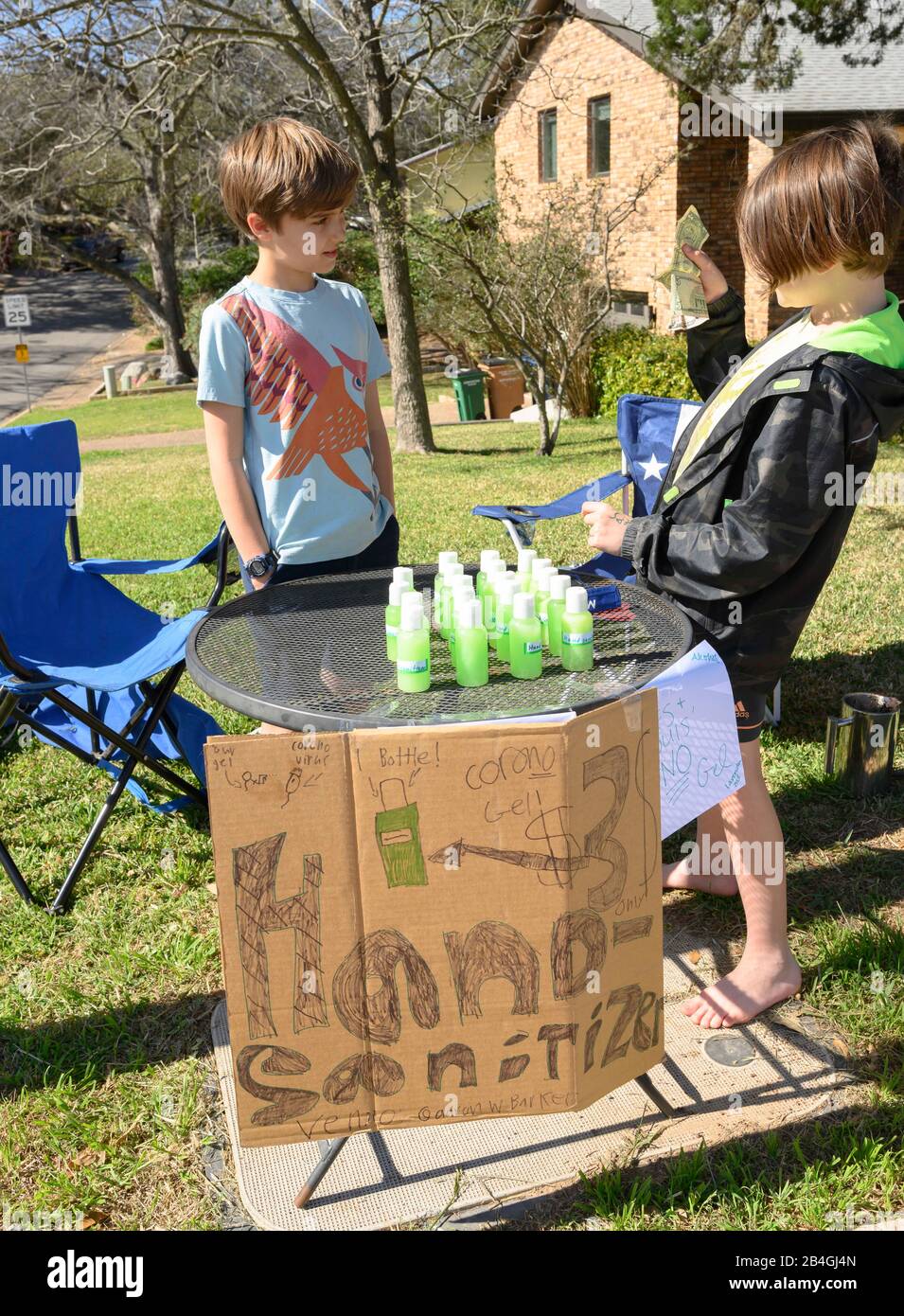 L'assainisseur pour les mains remplace la limonade alors que les jeunes entrepreneurs Miles Miller et Louis Spindle vendent de l'aseptisant pour les mains maison pour aider à combattre le coronavirus pour 3 $ une bouteille dans leur Austin, Texas, quartier après l'école. Banque D'Images