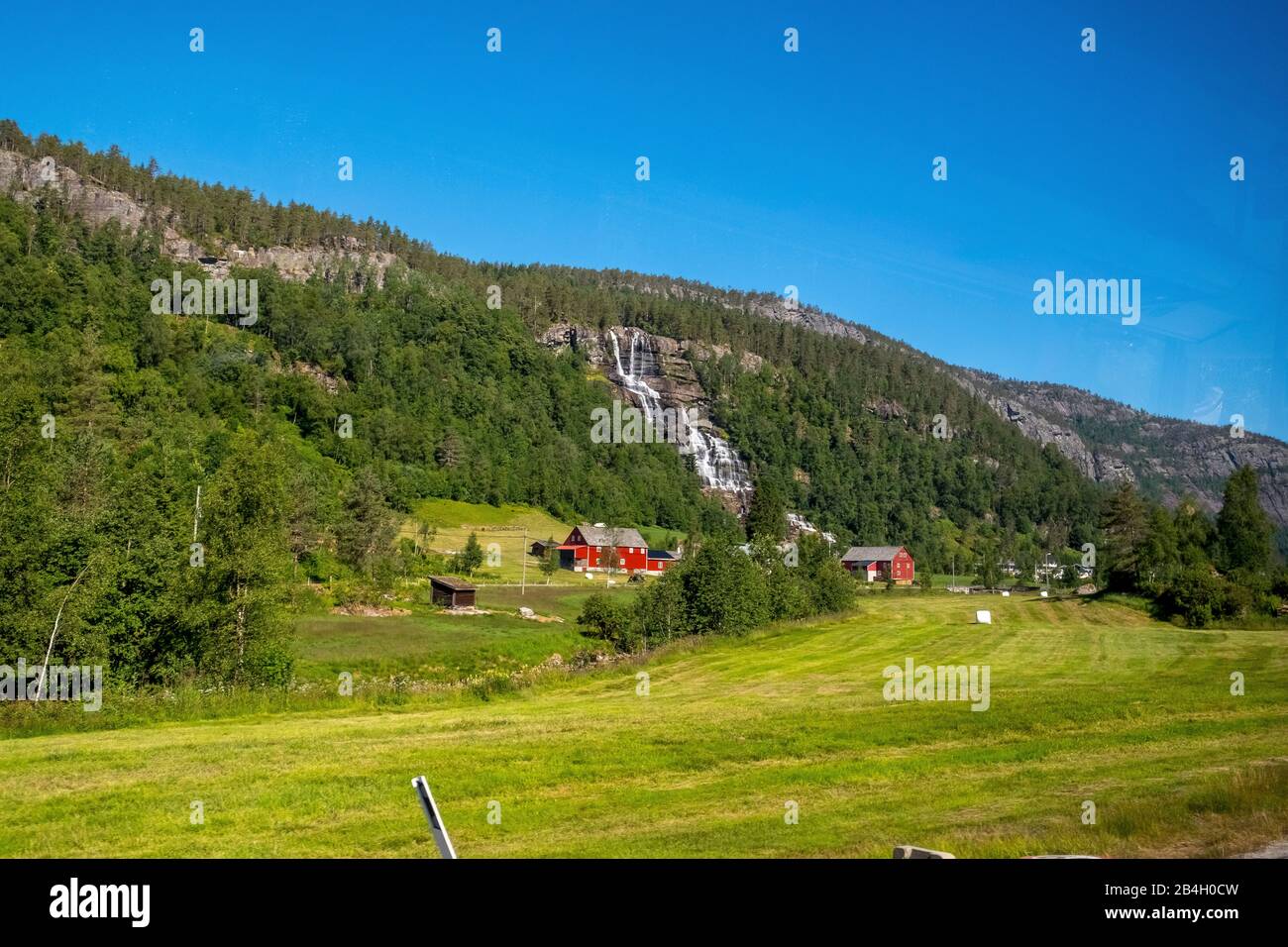 Huttes de montagne rouge, promenade ferroviaire avec la Flambahn, prés, arbres, cascade, montagnes, ciel bleu, Skulestadmo, Hordaland, Norvège, Scandinavie, Europe Banque D'Images