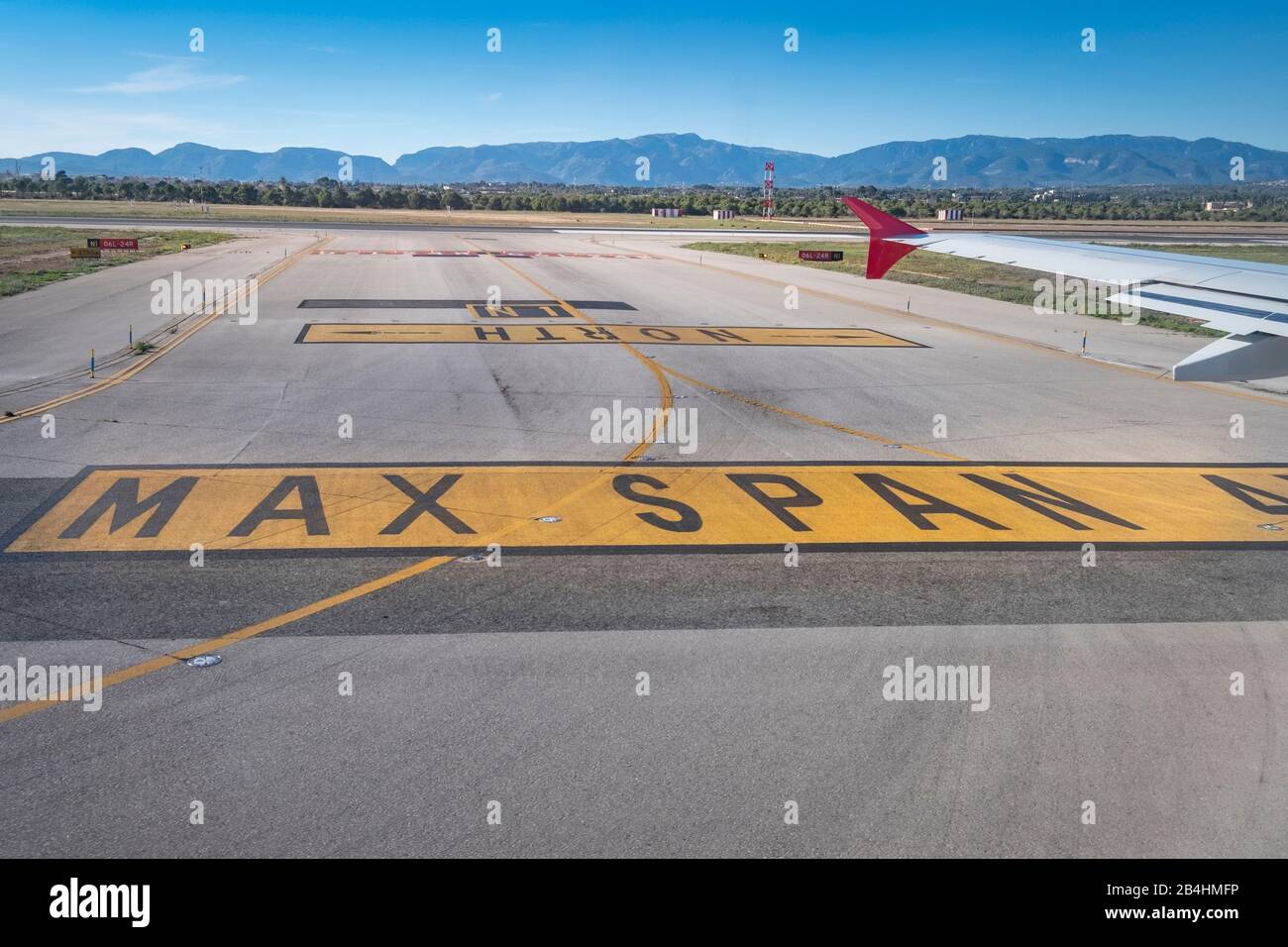 Vue depuis la fenêtre d'un avion sur la piste de Palma de Majorque avec chaînes de montagnes et marquages de terrain d'aviation Banque D'Images