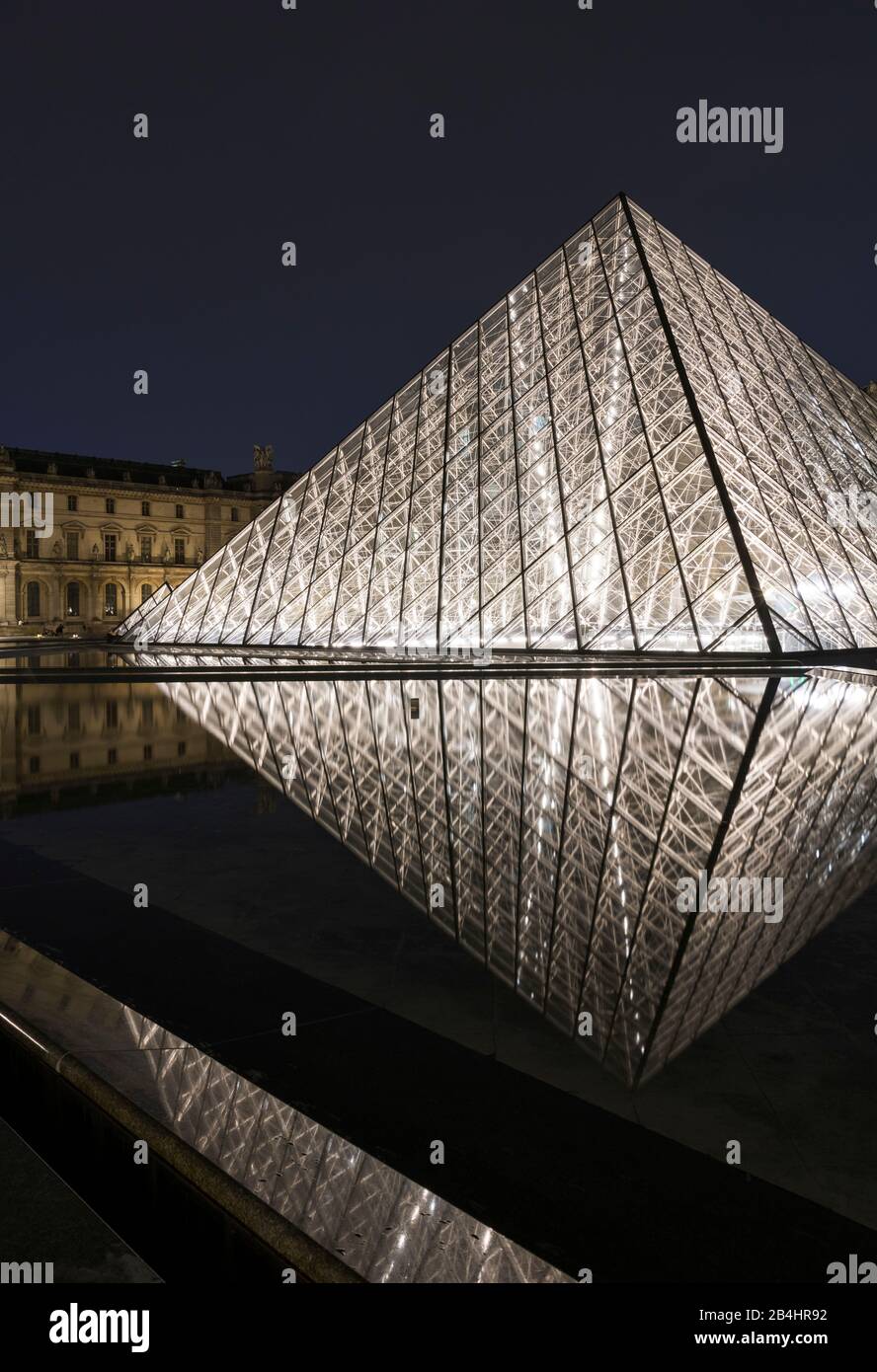 Pyramide de verre illuminée la nuit dans le Louvre se reflète dans l'eau, Paris, France, Europe Banque D'Images