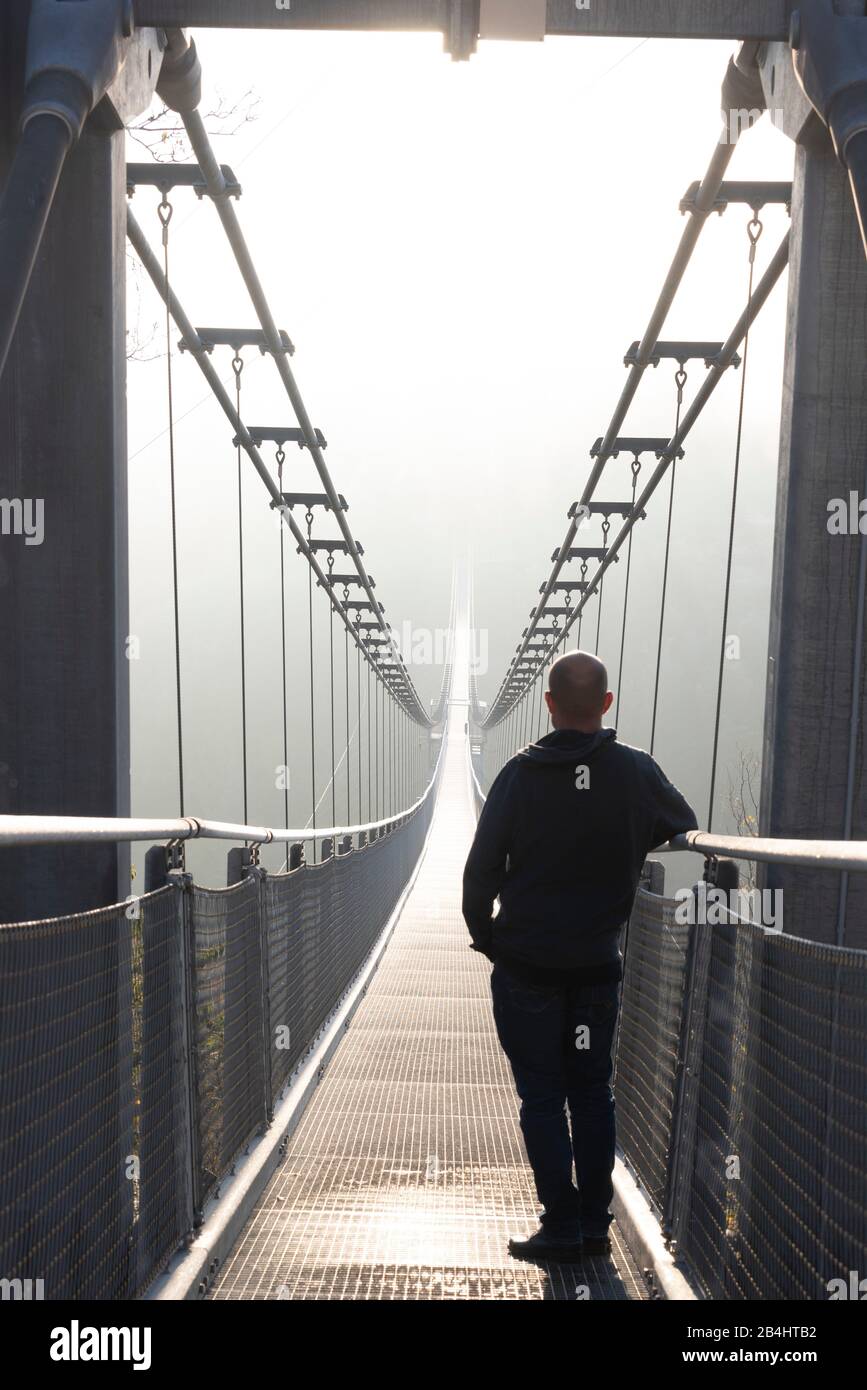 Allemagne, Saxe-Anhalt, Haute-Harz, un homme se tient sur le pont suspendu TitanRT, résine Rappbodetalsperre. Banque D'Images